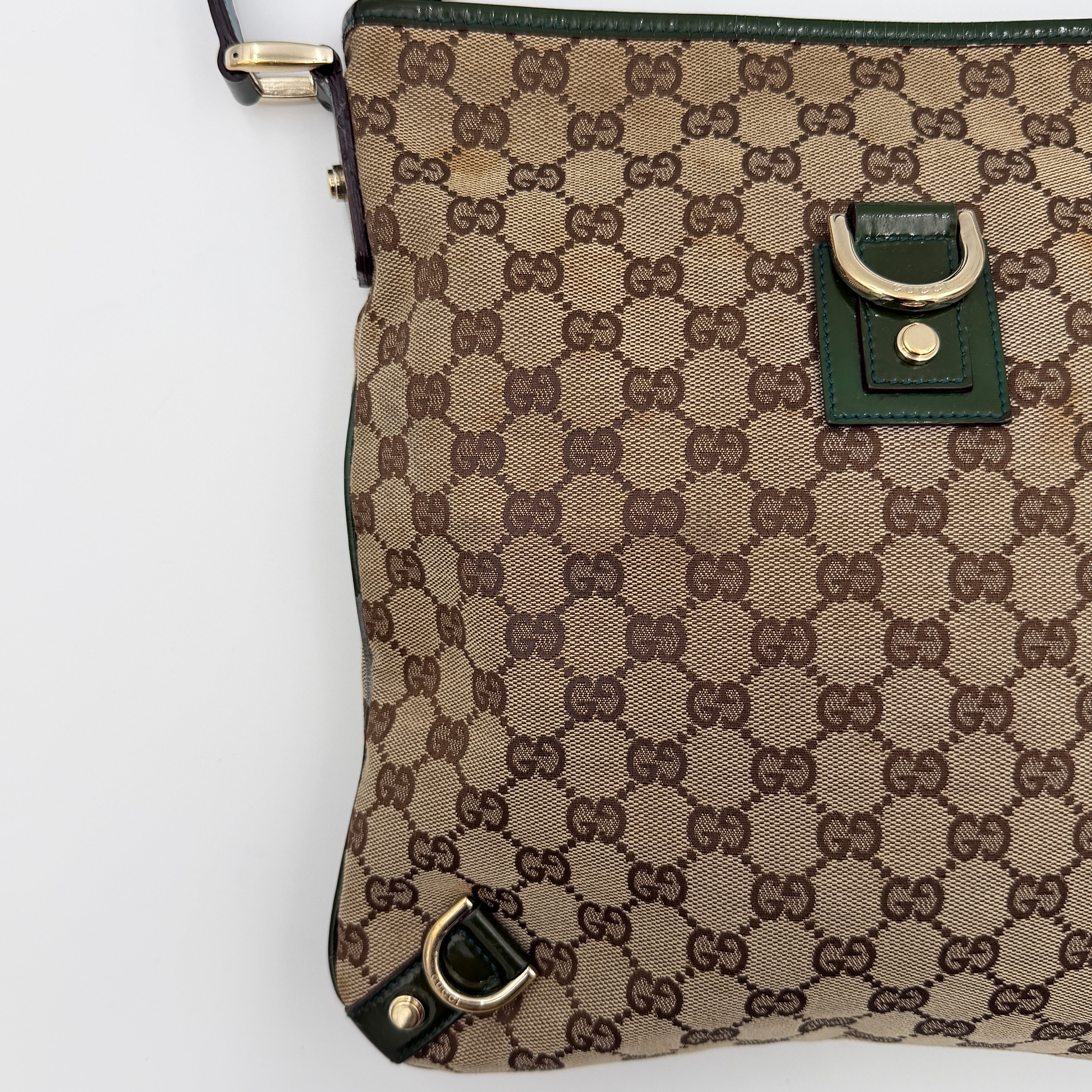 Gucci GG Monogram Abbey D Ring Crossbody Bag in beige canvas with green leather trim and gold-tone hardware, featuring an adjustable green strap.