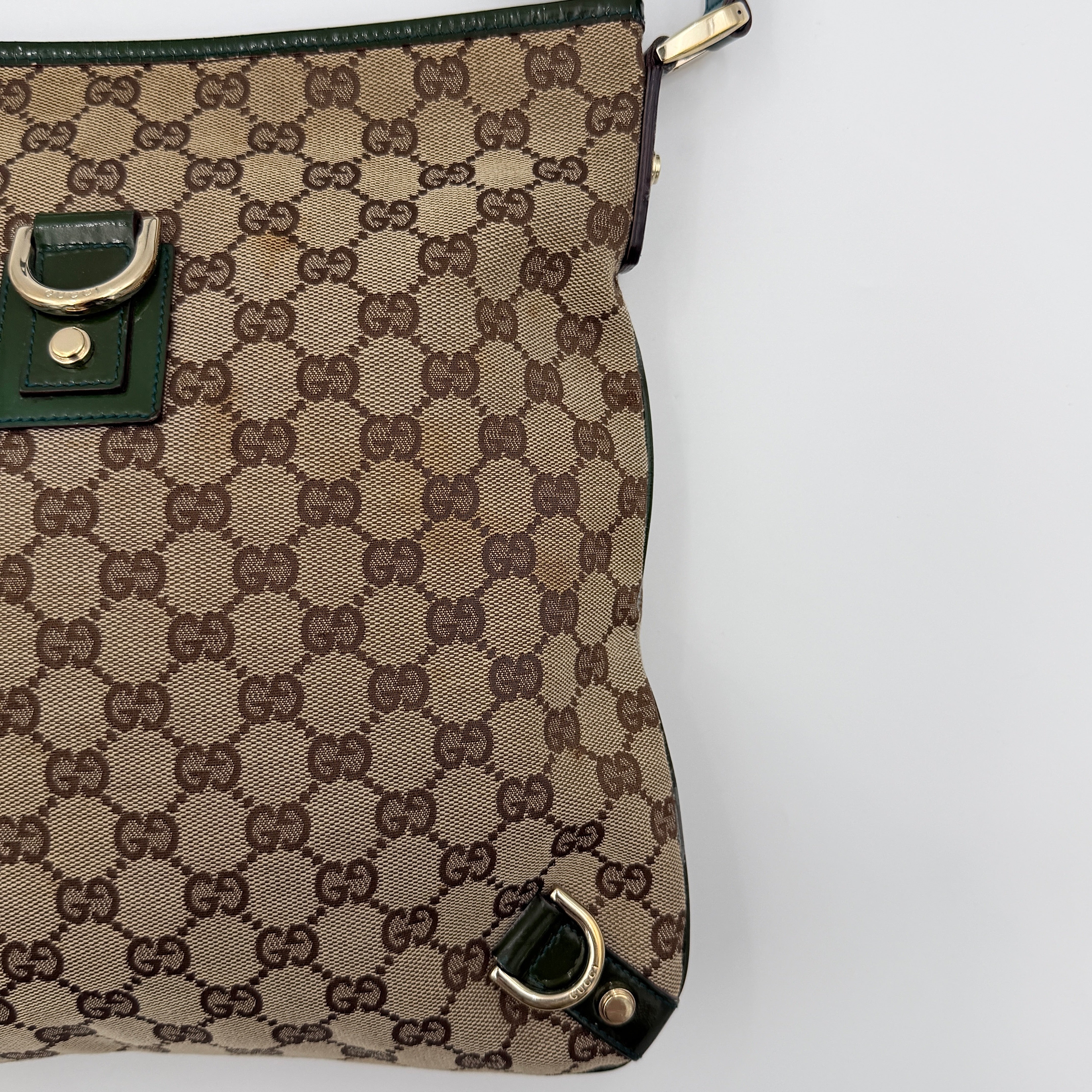 Gucci GG Monogram Abbey D Ring Crossbody Bag in beige canvas with green leather trim and gold-tone hardware, featuring an adjustable green strap.