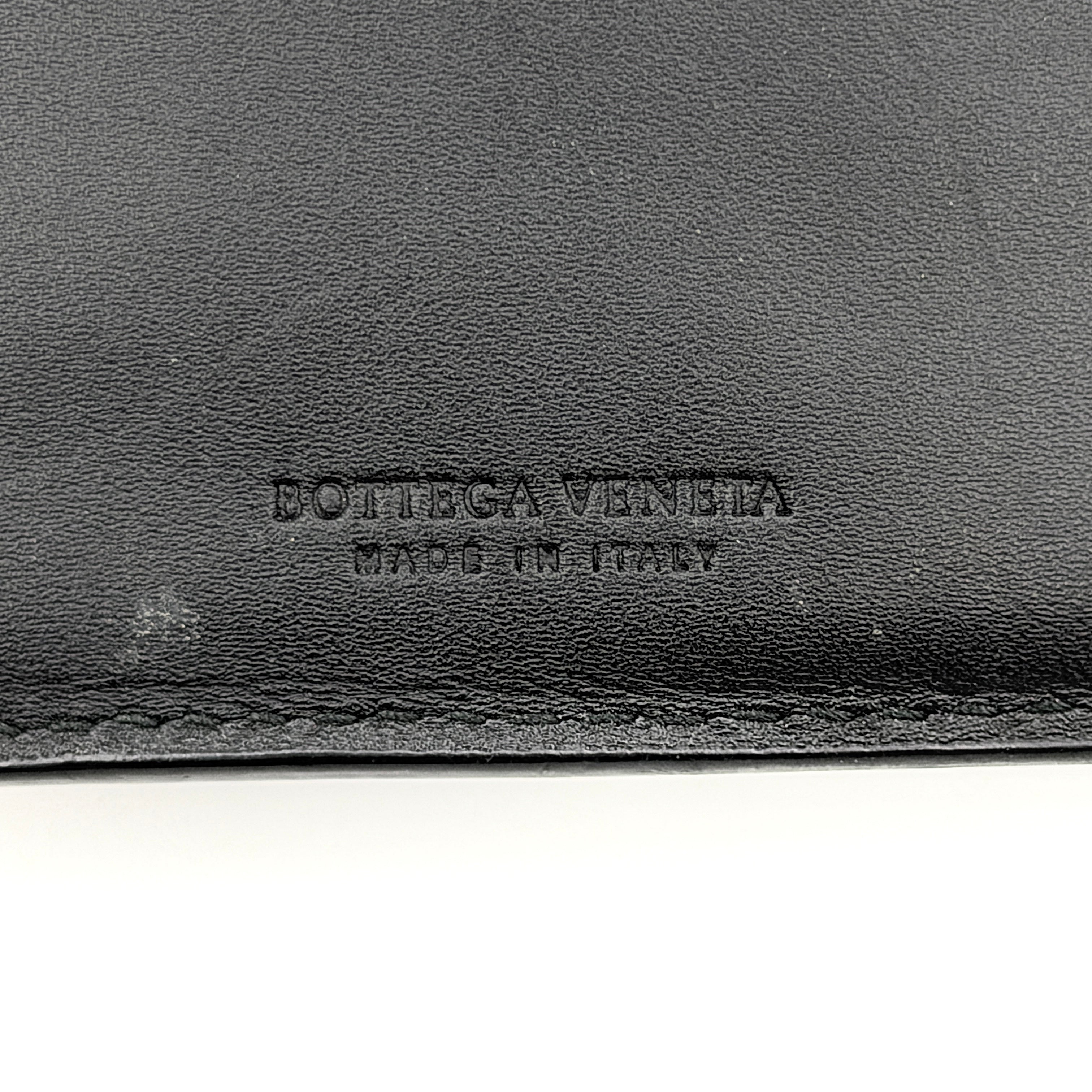Bottega Veneta black intrecciato leather wallet shown against a plain background highlighting its woven texture.