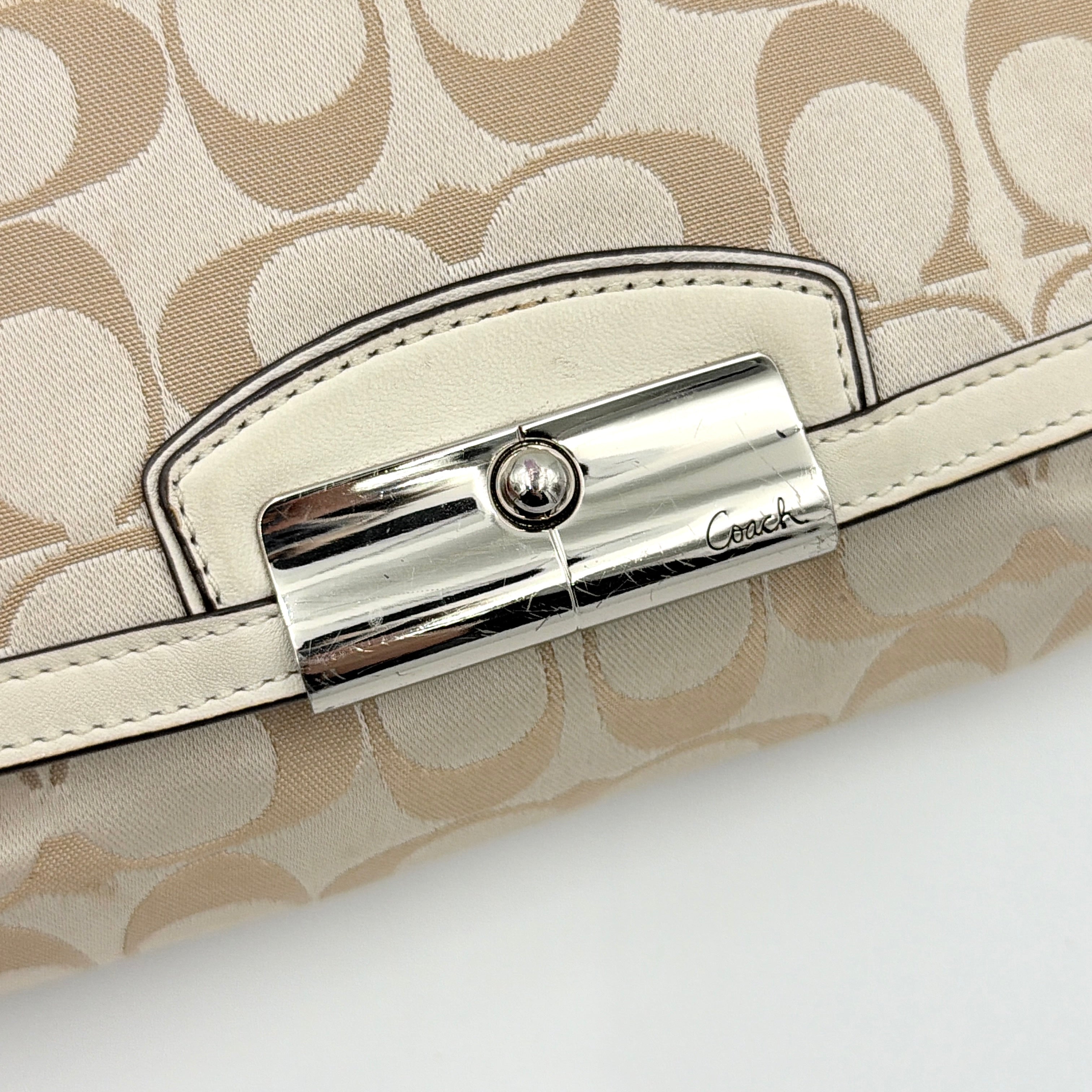 Coach Signature Kristin Shoulder Bag in beige and white jacquard canvas with white leather trim, presented with a polished silver push-lock clasp.