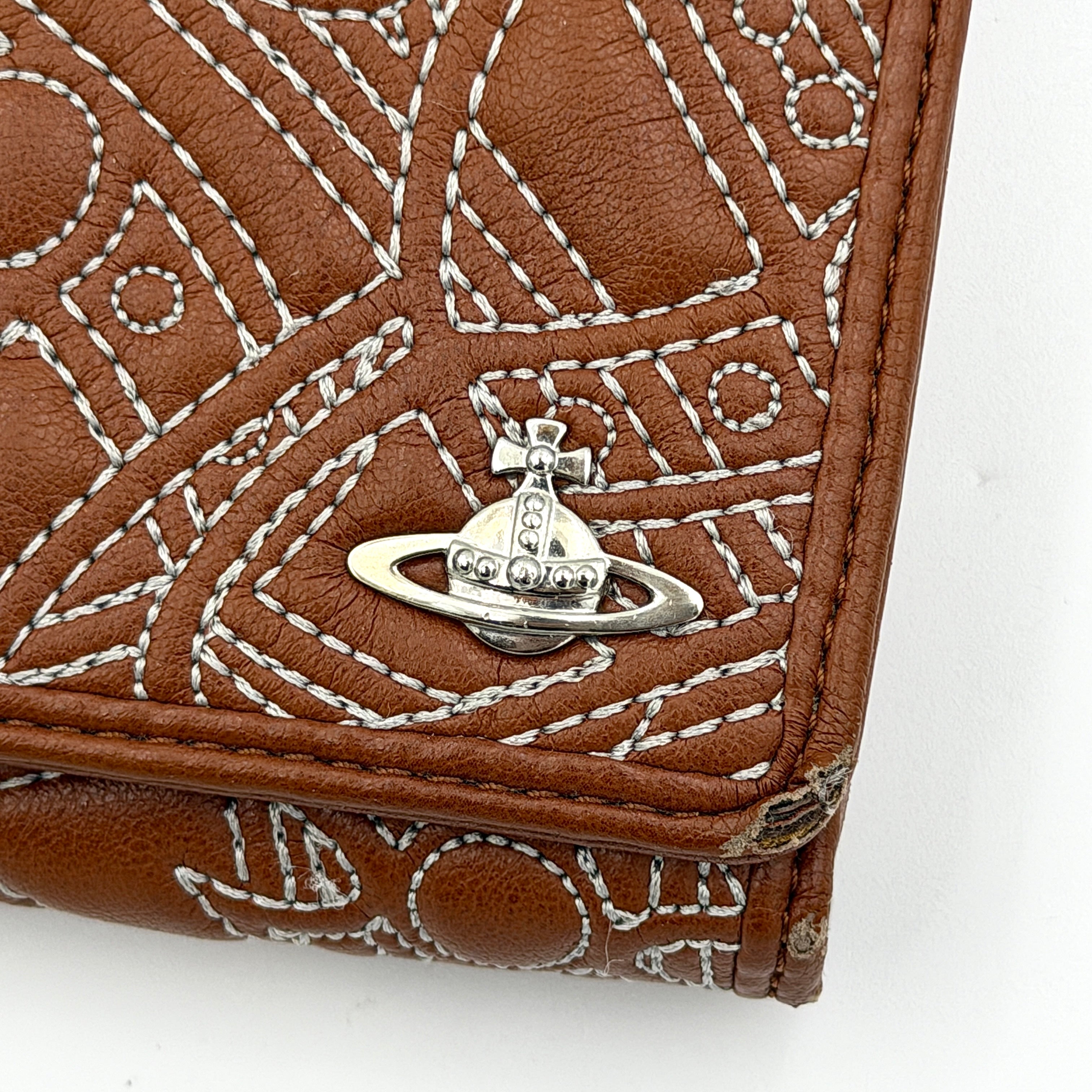Vivienne Westwood long wallet in chestnut brown leather with white contrast stitching and silver orb embellishment.