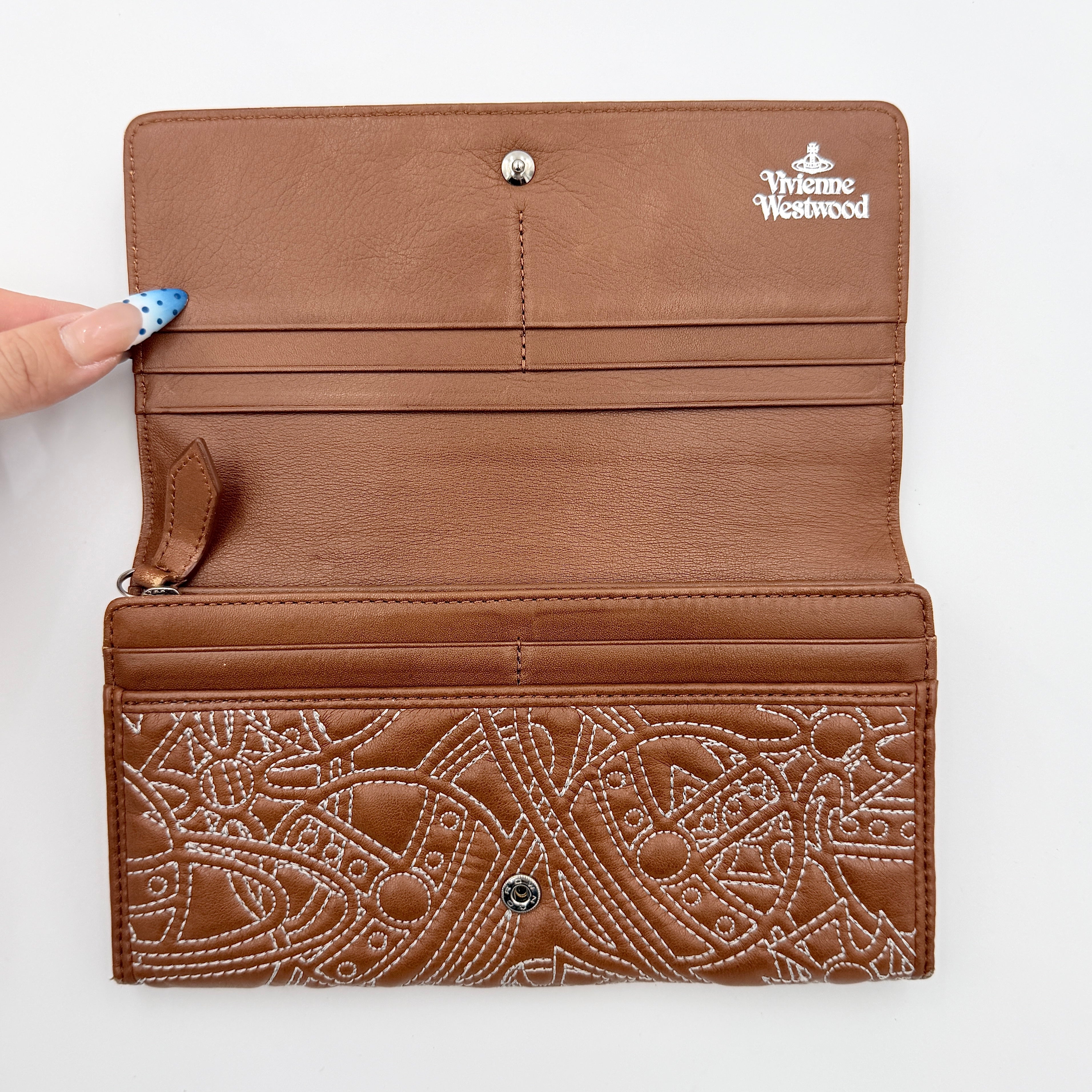 Vivienne Westwood long wallet in chestnut brown leather with white contrast stitching and silver orb embellishment.