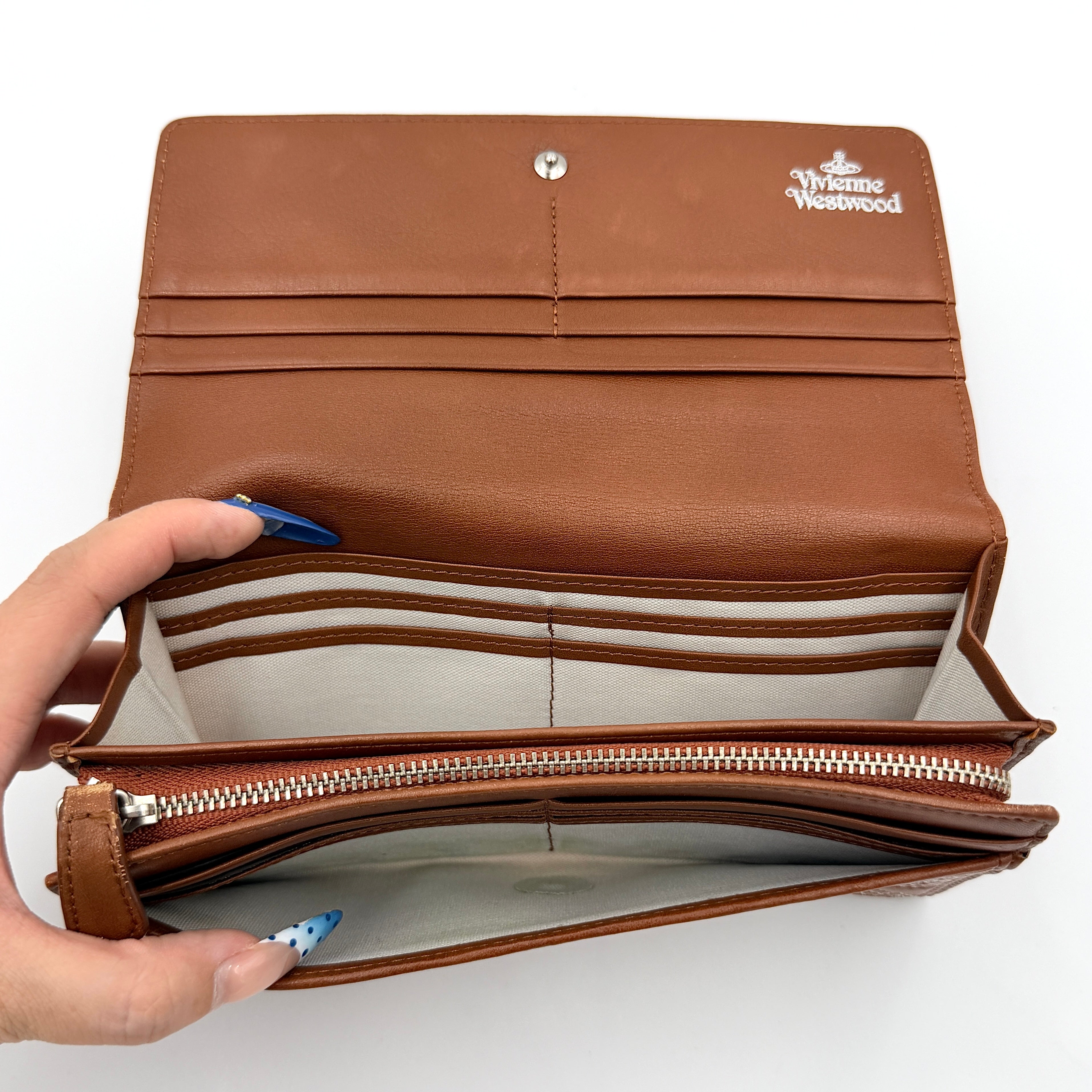 Vivienne Westwood long wallet in chestnut brown leather with white contrast stitching and silver orb embellishment.