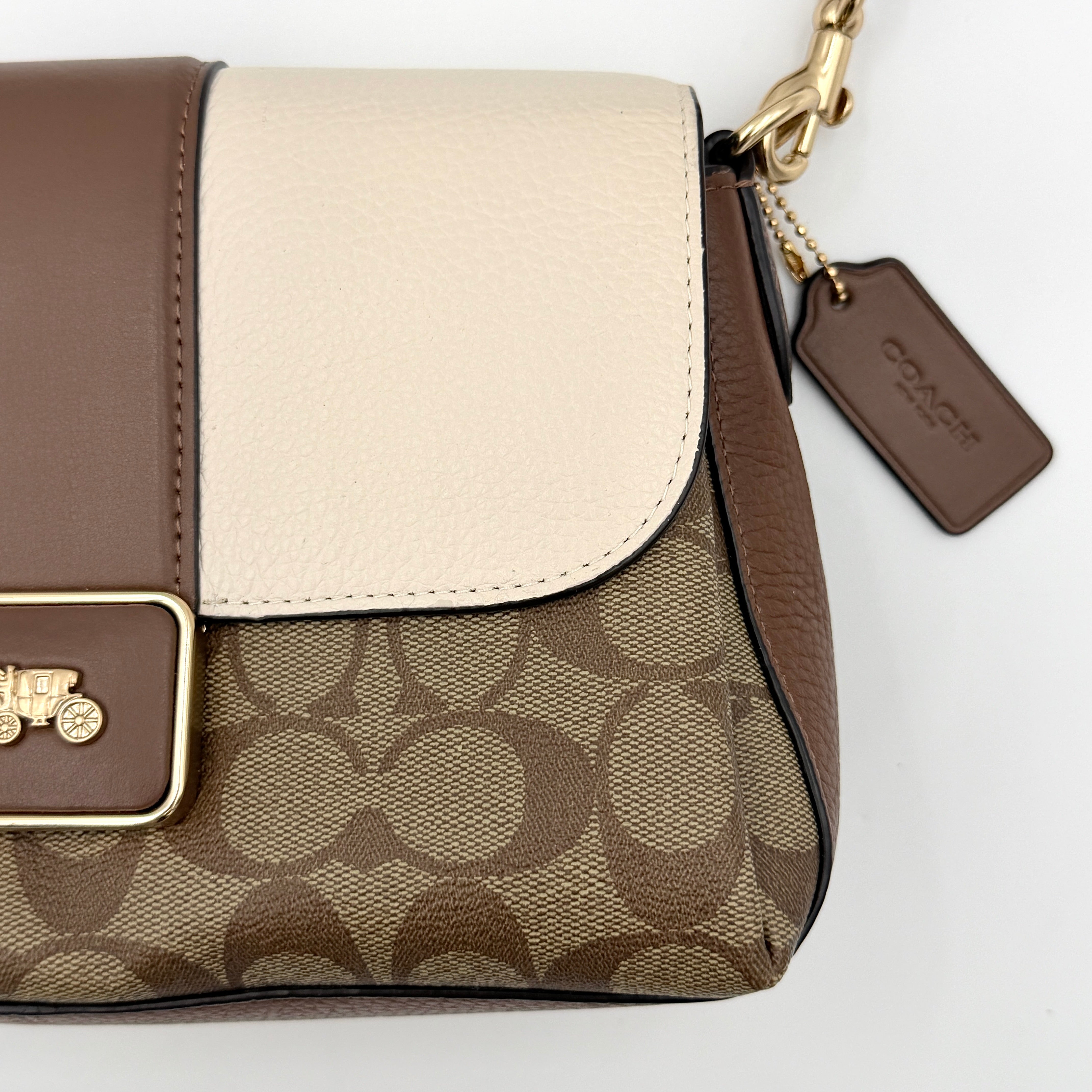 Coach Signature Grace Shoulder Bag in beige and white leather with monogram canvas and gold hardware, displayed with structured silhouette and top handle.