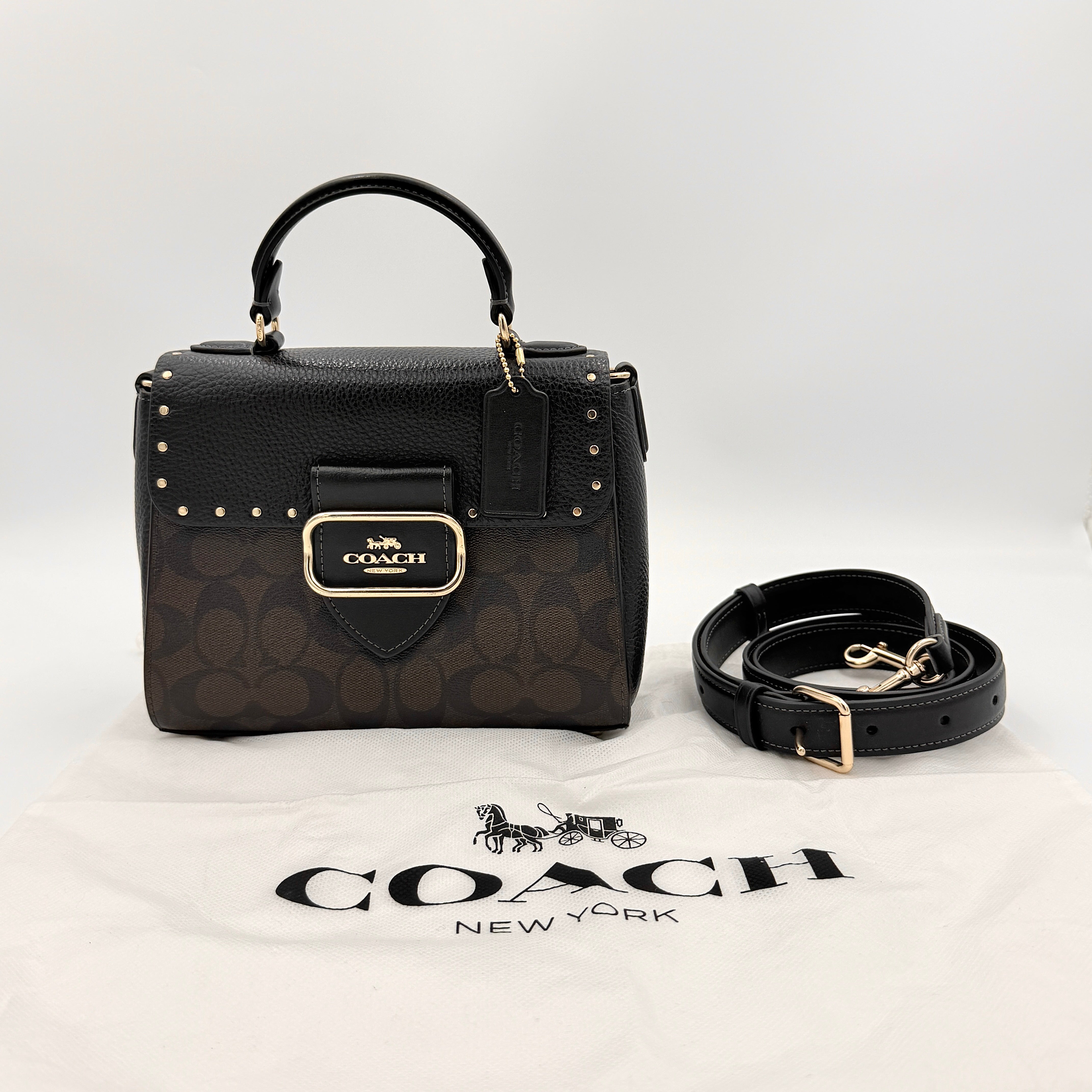Coach Morgan Top Handle Bag in brown and black signature canvas with pebbled leather, gold hardware and detachable strap displayed alongside a Coach dustbag.