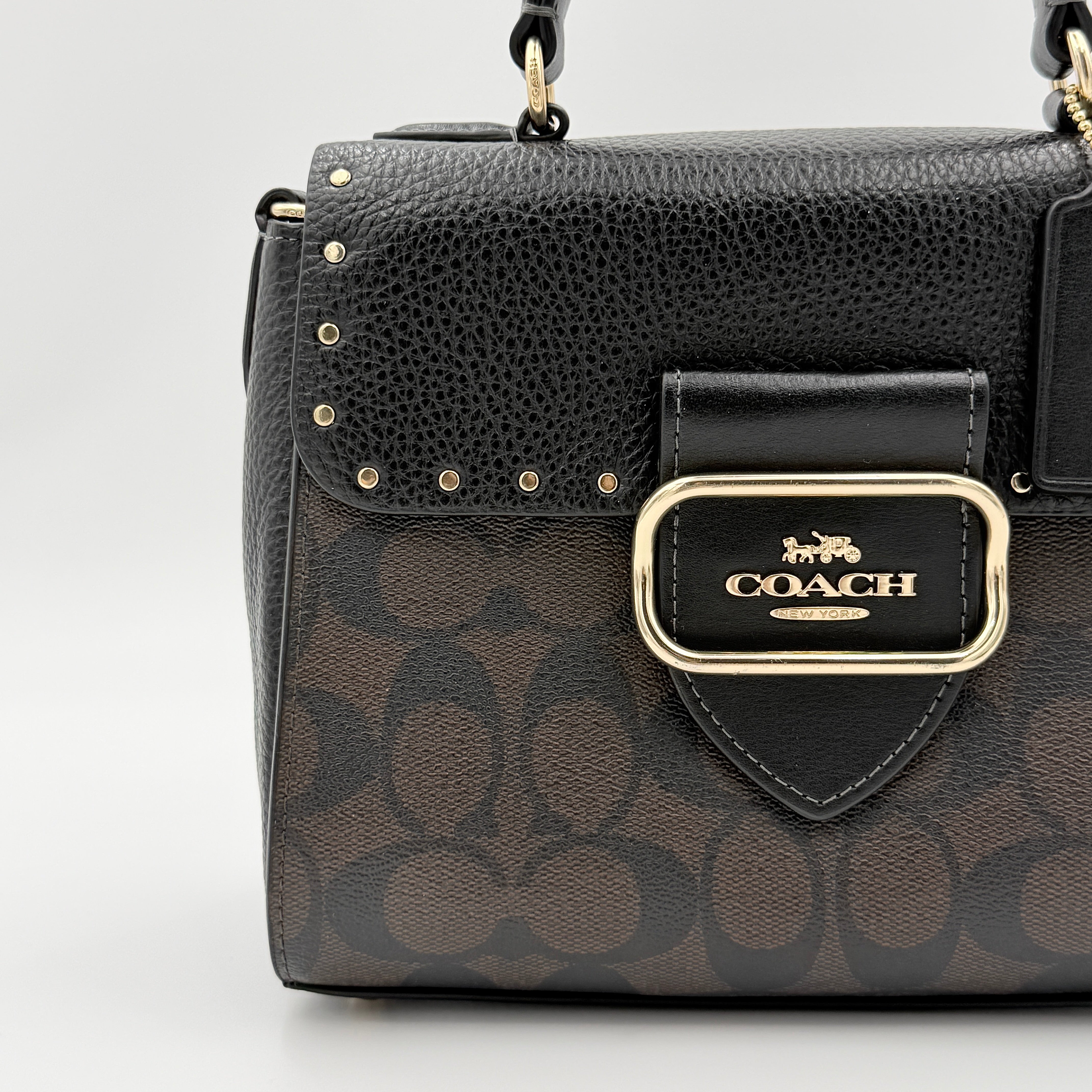 Coach Morgan Top Handle Bag in brown and black signature canvas with pebbled leather, gold hardware and detachable strap displayed alongside a Coach dustbag.