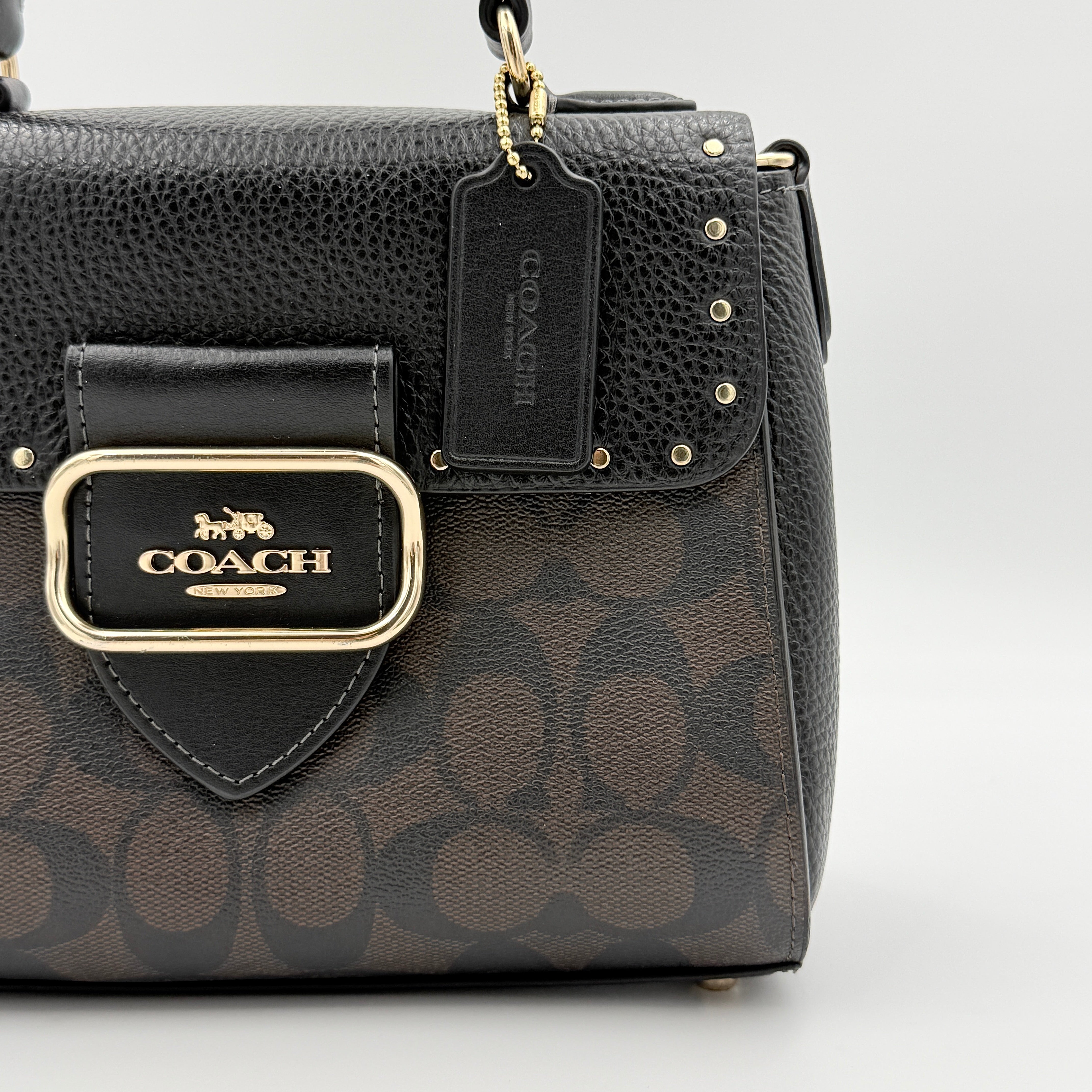 Coach Morgan Top Handle Bag in brown and black signature canvas with pebbled leather, gold hardware and detachable strap displayed alongside a Coach dustbag.