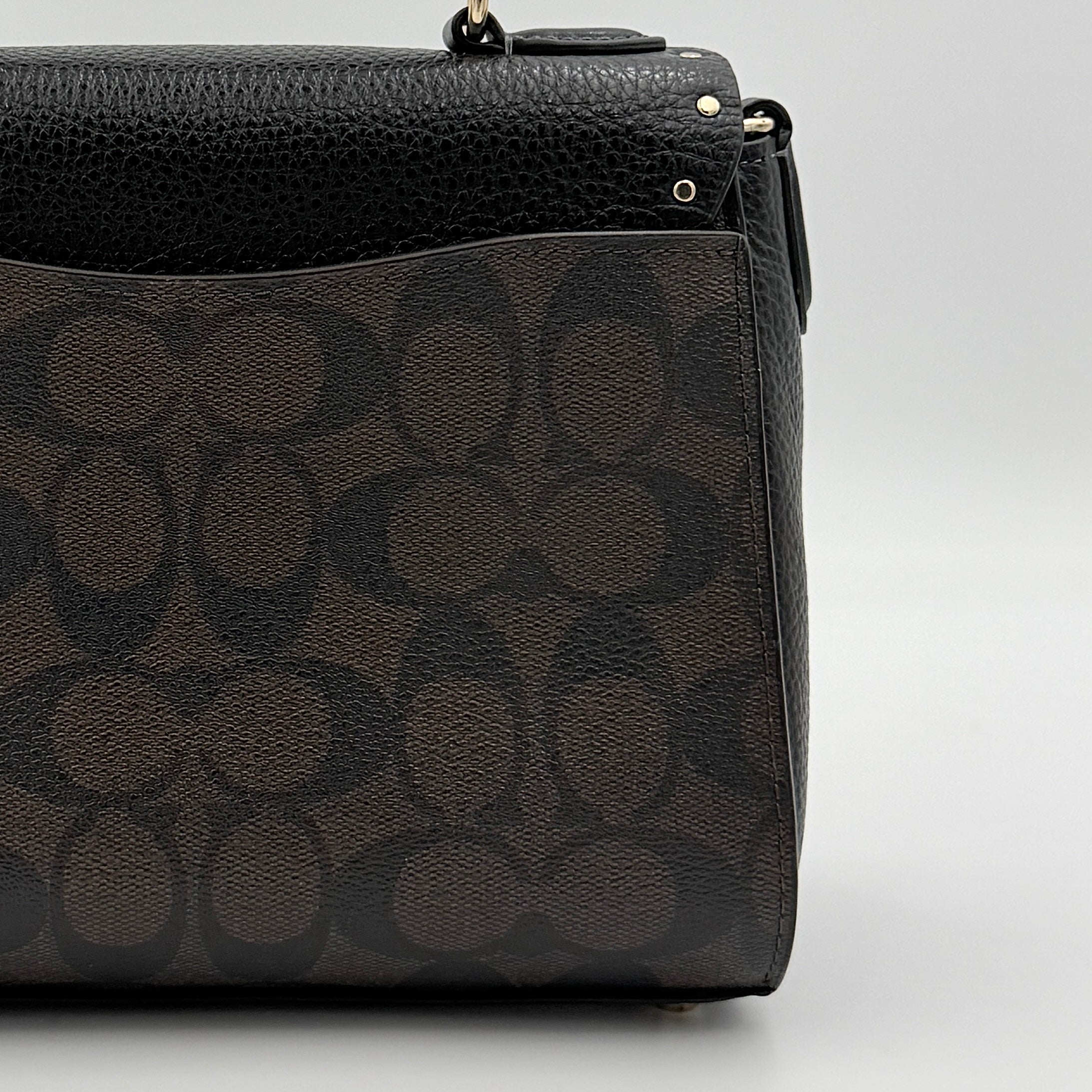 Coach Morgan Top Handle Bag in brown and black signature canvas with pebbled leather, gold hardware and detachable strap displayed alongside a Coach dustbag.