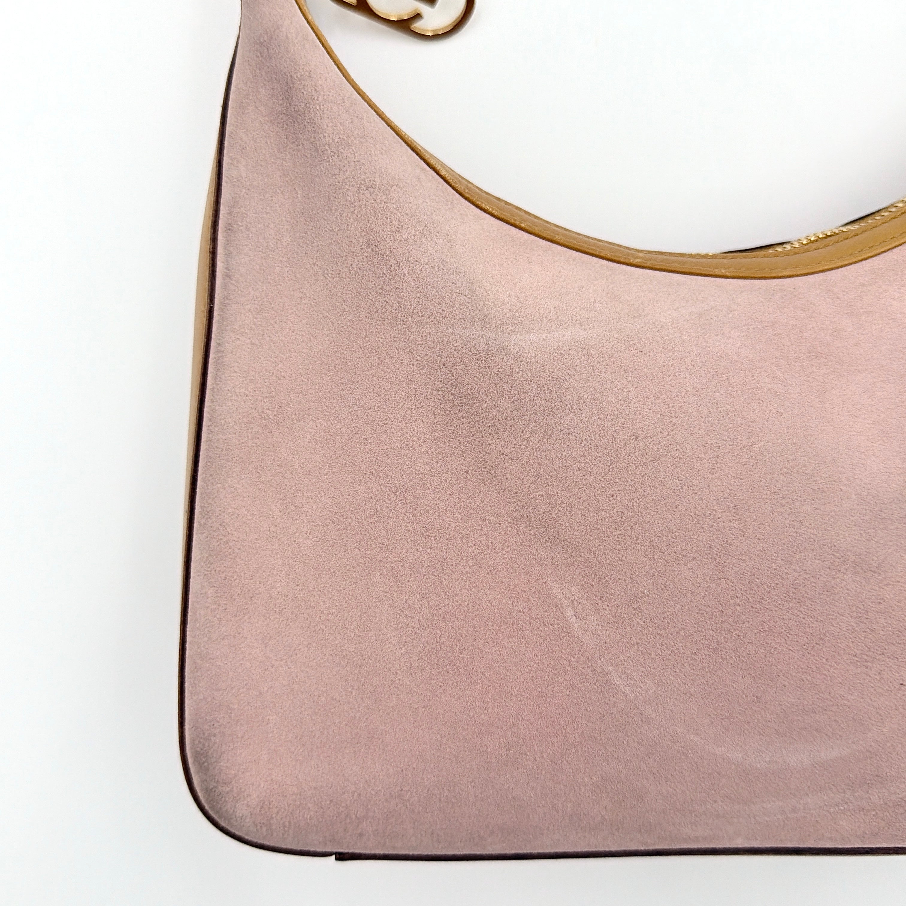 Gucci hobo shoulder bag in blush pink suede with tan leather trim and gold hardware, displayed against a white background.