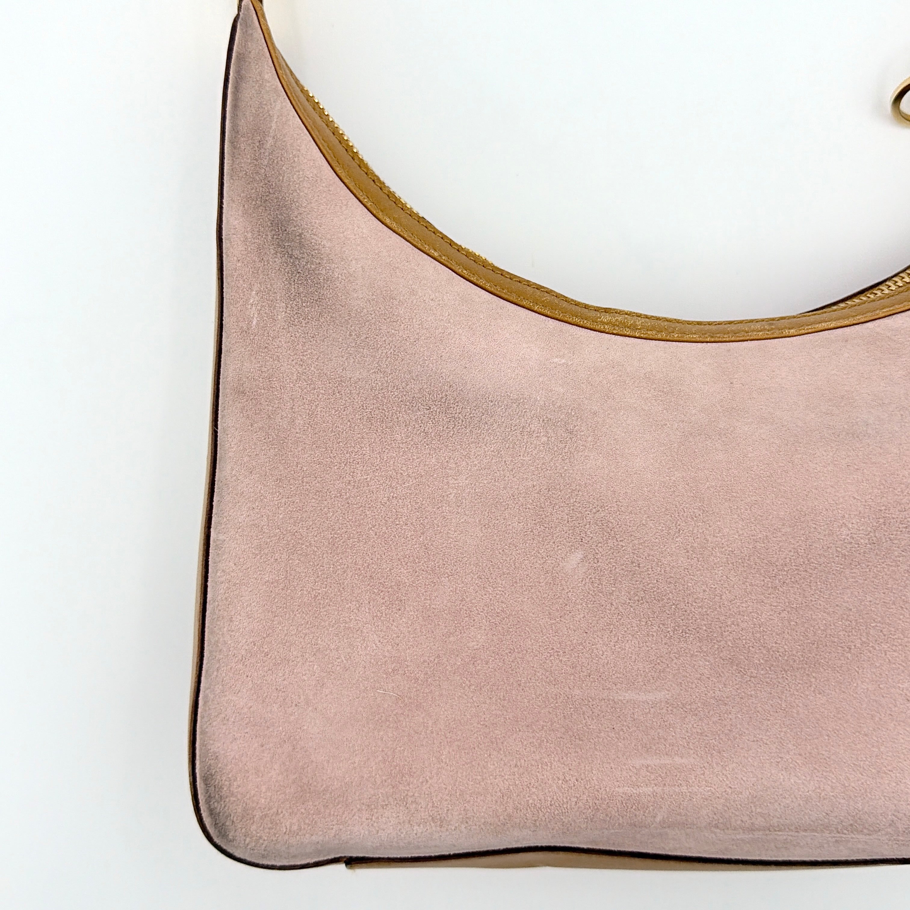 Gucci hobo shoulder bag in blush pink suede with tan leather trim and gold hardware, displayed against a white background.