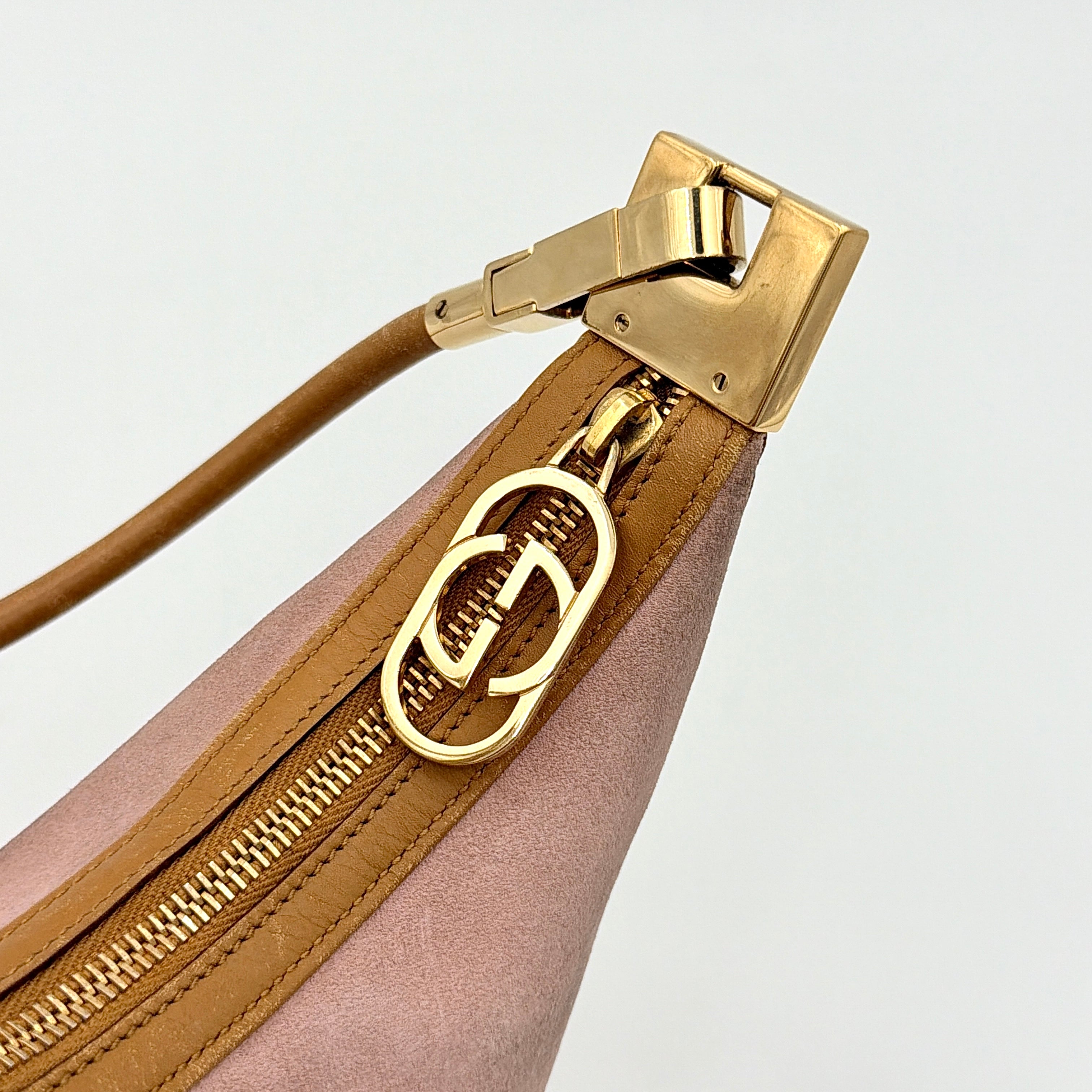Gucci hobo shoulder bag in blush pink suede with tan leather trim and gold hardware, displayed against a white background.