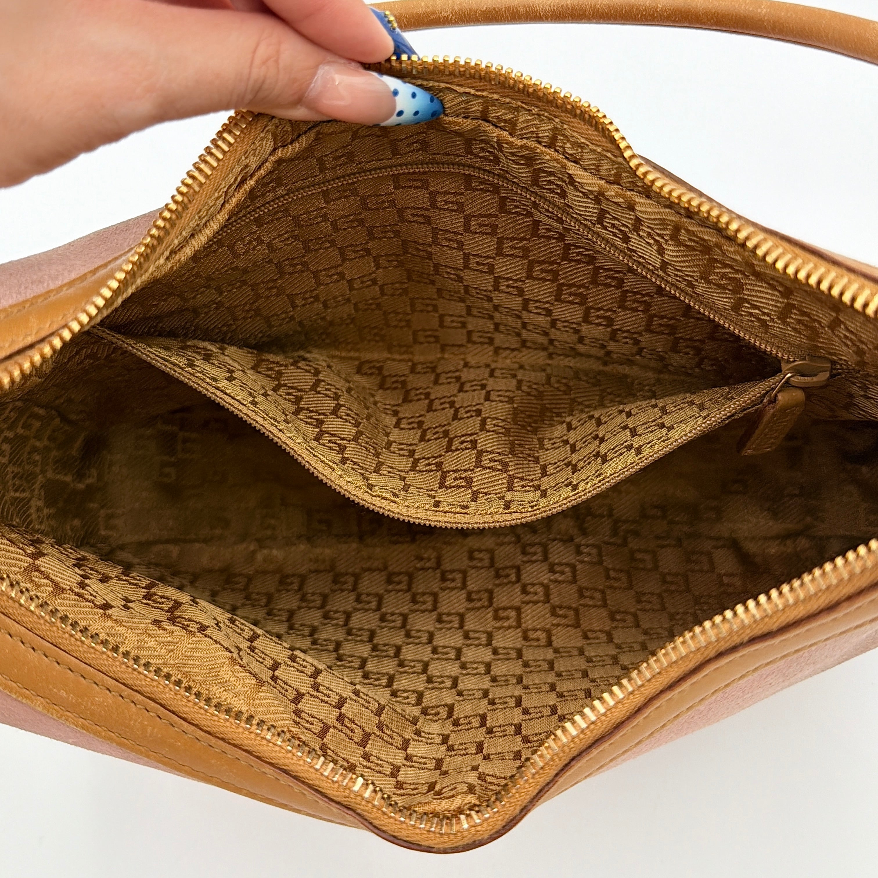 Gucci hobo shoulder bag in blush pink suede with tan leather trim and gold hardware, displayed against a white background.