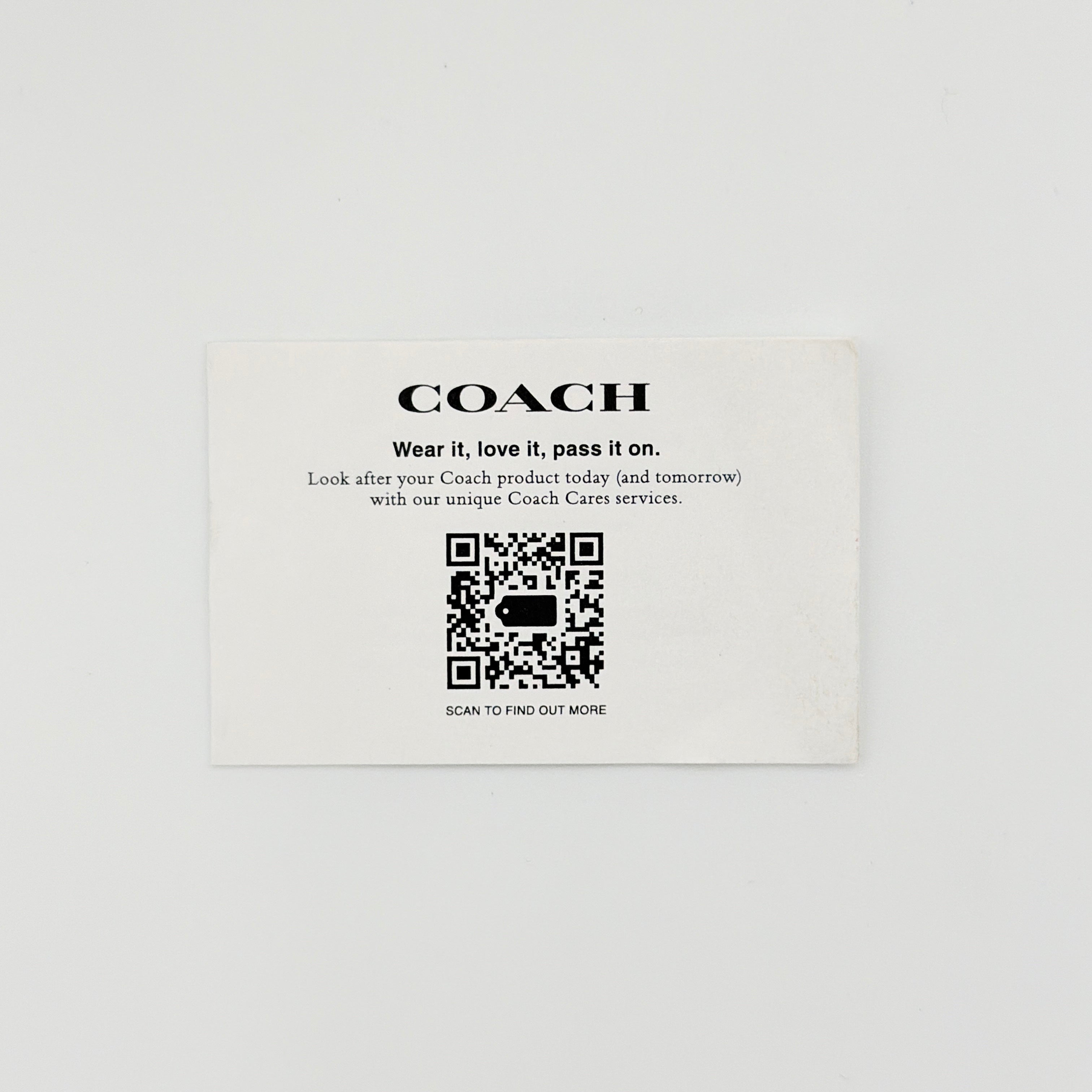 Coach 2Way Signature Lillie Carryall in white canvas with gold hardware and multicolour floral print, accompanied by a detachable white shoulder strap.