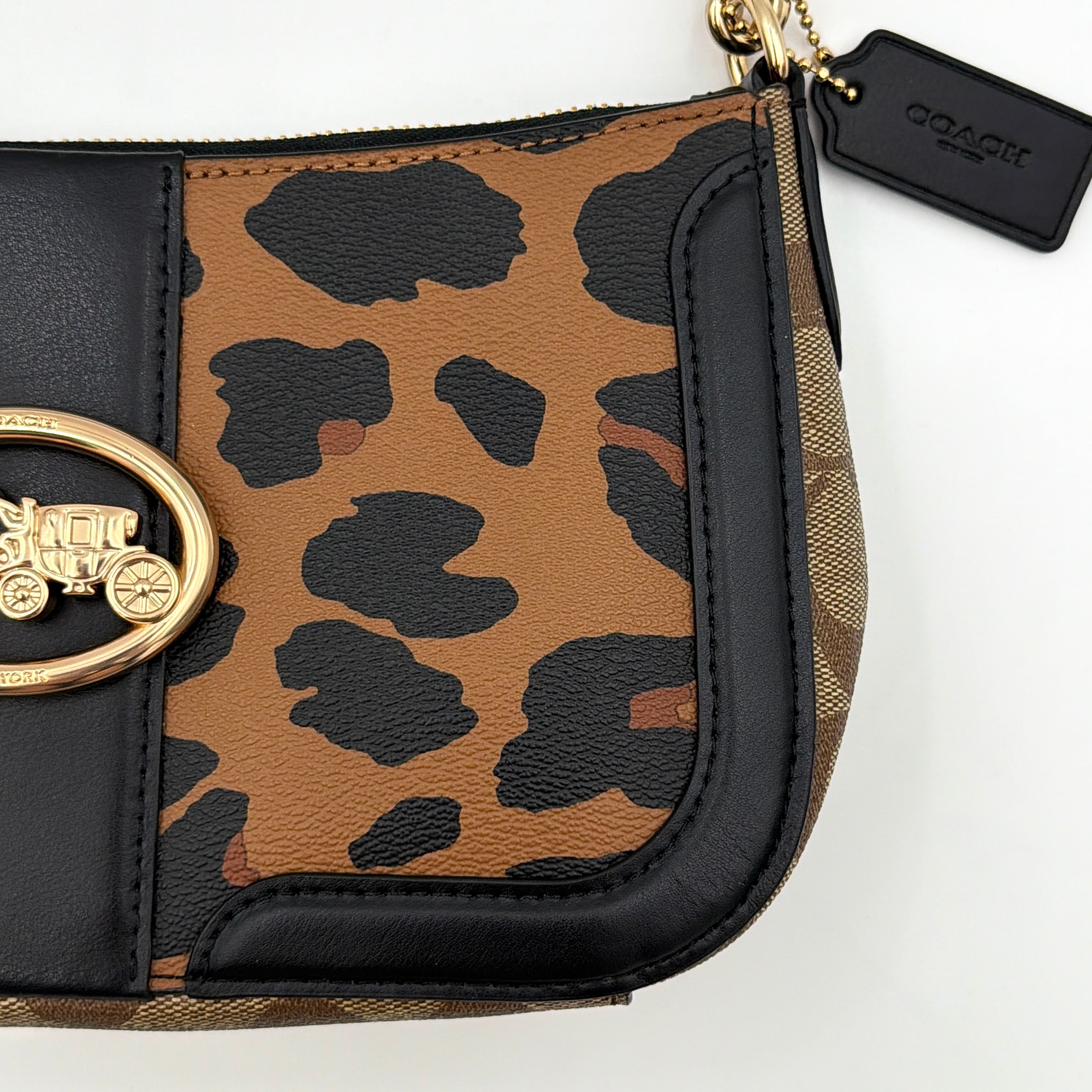 Coach Georgie Shoulder Bag in brown and black leopard print with gold horse and carriage medallion, displayed with its detachable chain and leather strap.