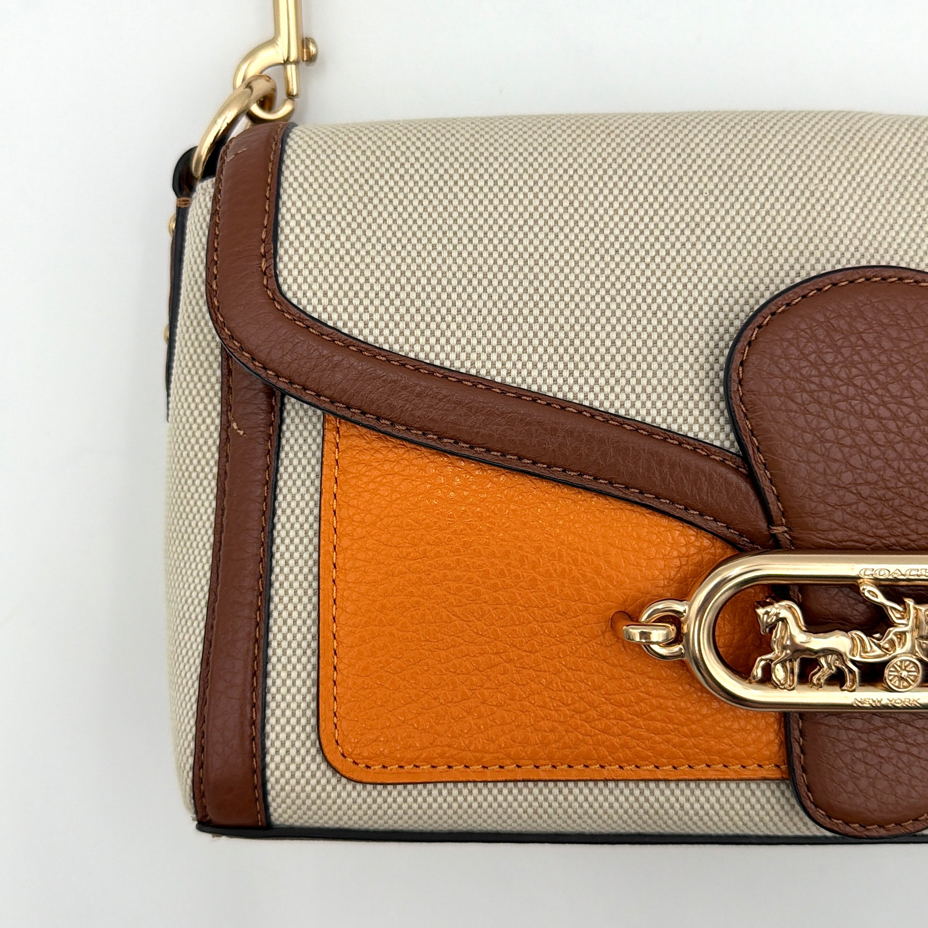 Coach Jade 2Way Shoulder Bag in sand canvas with amber and brown leather trim, gold-tone carriage hardware, and detachable strap.