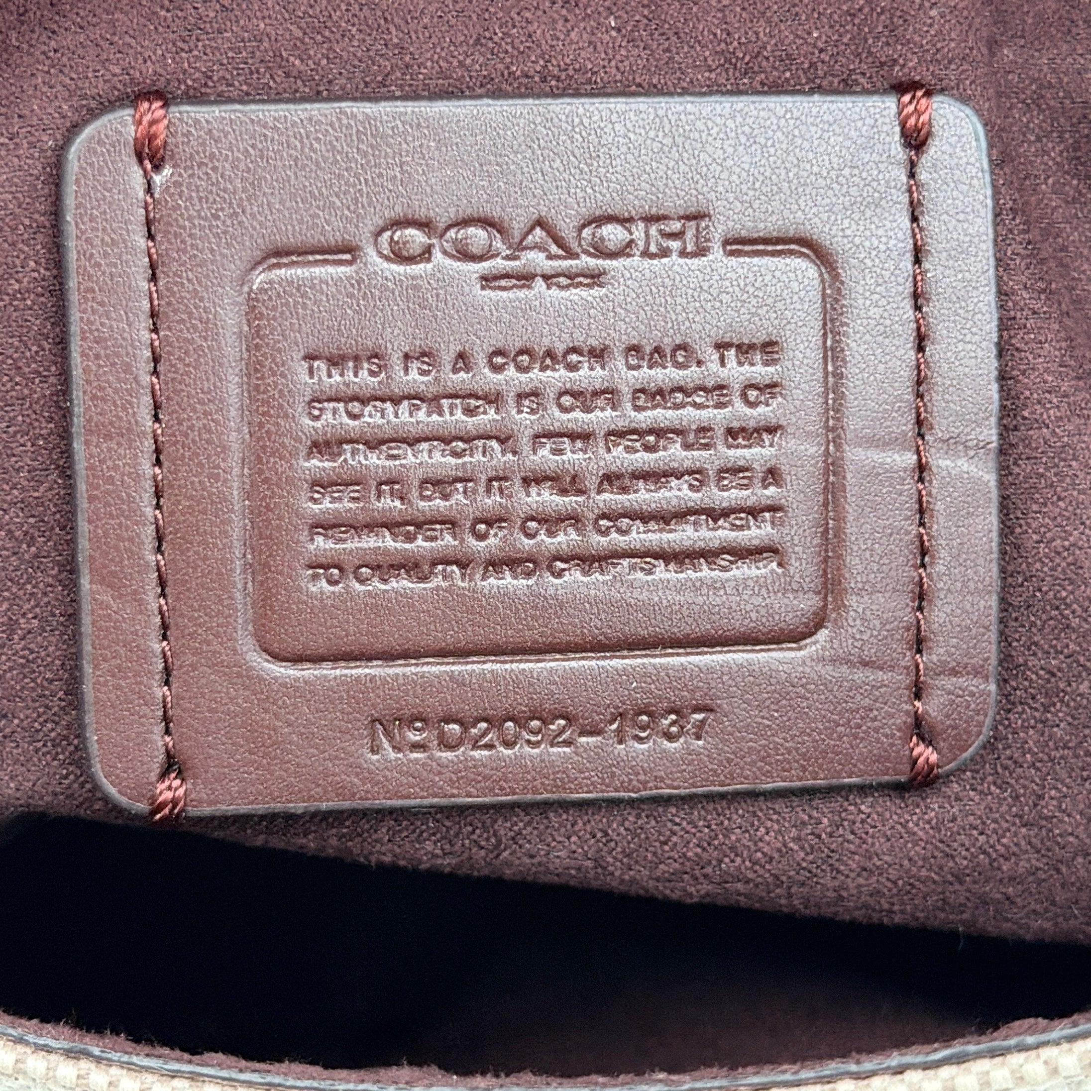 Coach Jade 2Way Shoulder Bag in sand canvas with amber and brown leather trim, gold-tone carriage hardware, and detachable strap.