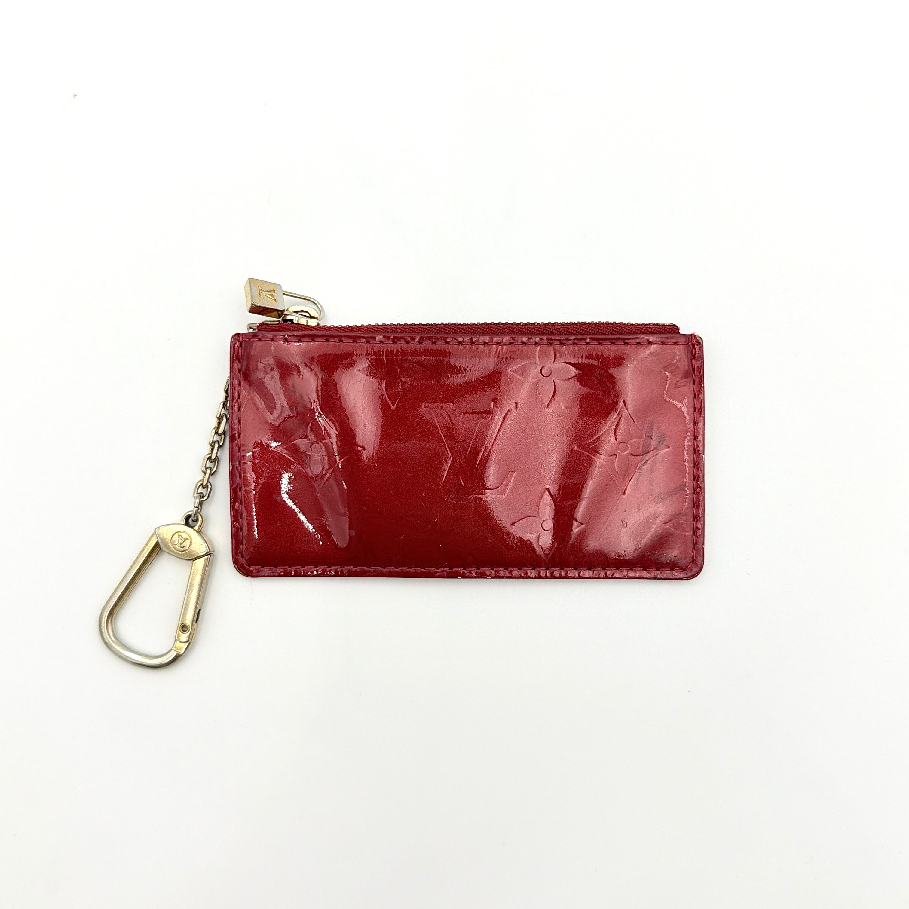 Louis Vuitton Vernis Coin Case in amethyst red patent leather with gold-tone key chain and zip closure, embossed with monogram pattern.