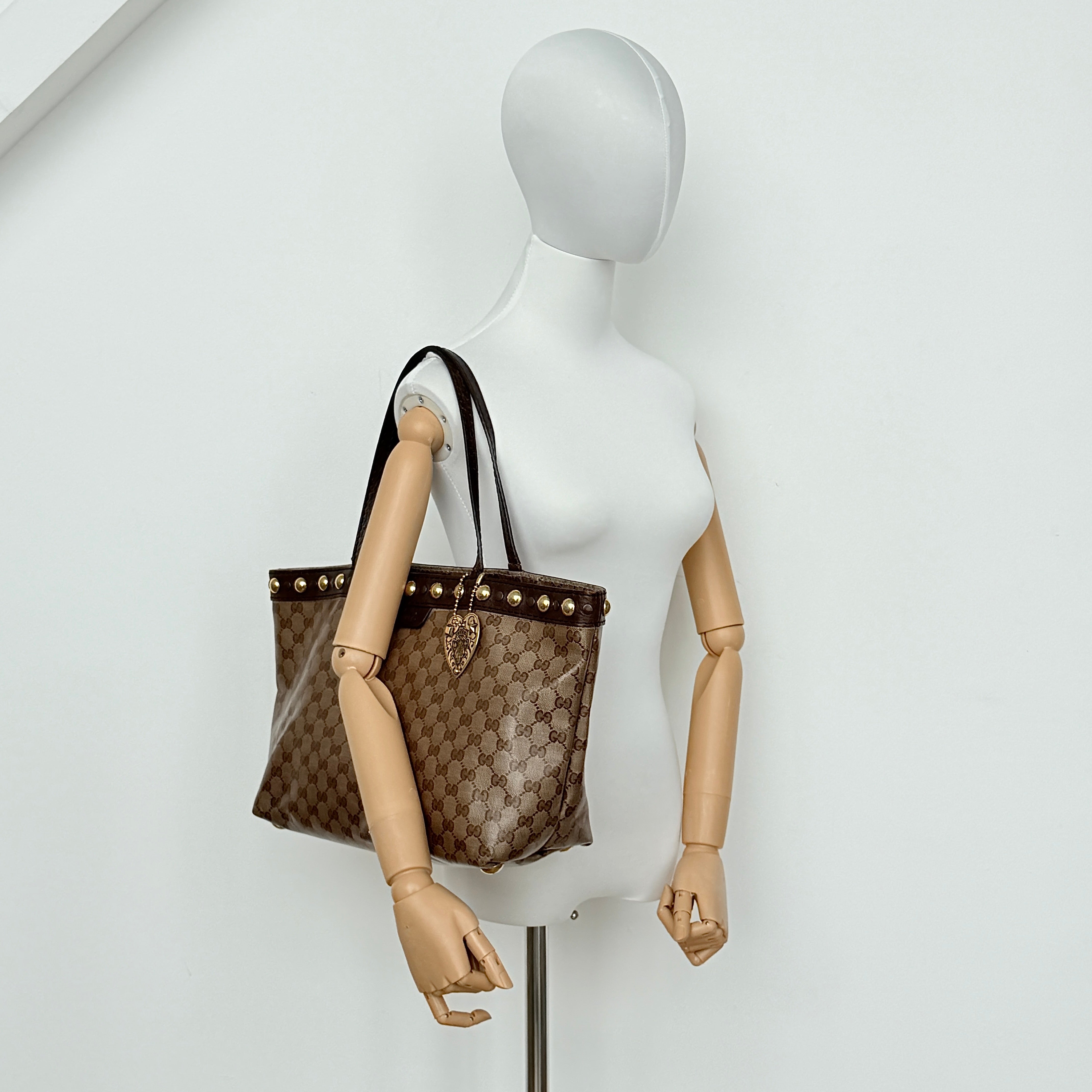 Gucci Babouska shoulder bag in GG monogram crystal canvas with gold-tone stud details and brown leather trim.