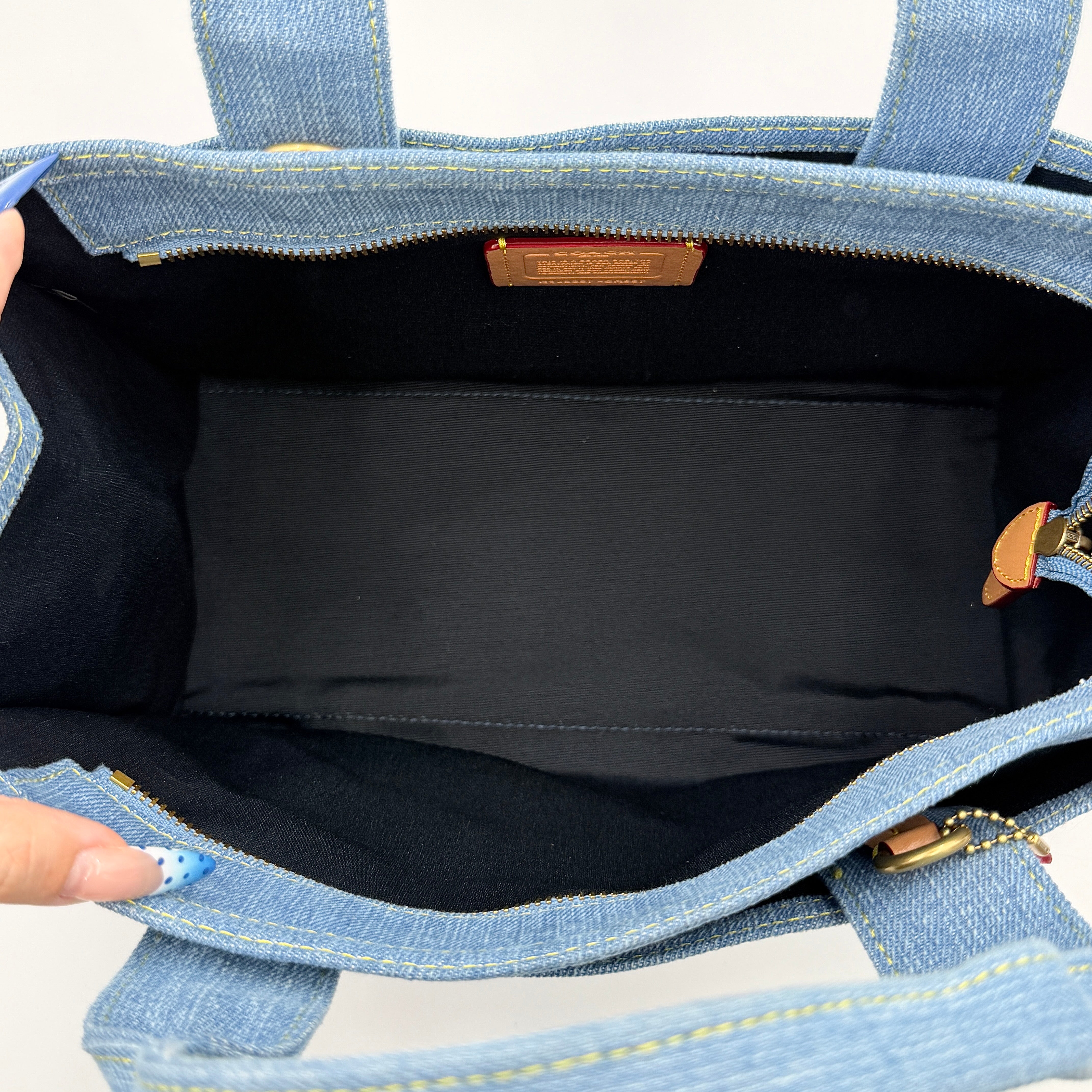 Coach denim 2Way Logo 20 Tote Bag in blue, embroidered with 'Coach New York', shown with detachable navy strap.