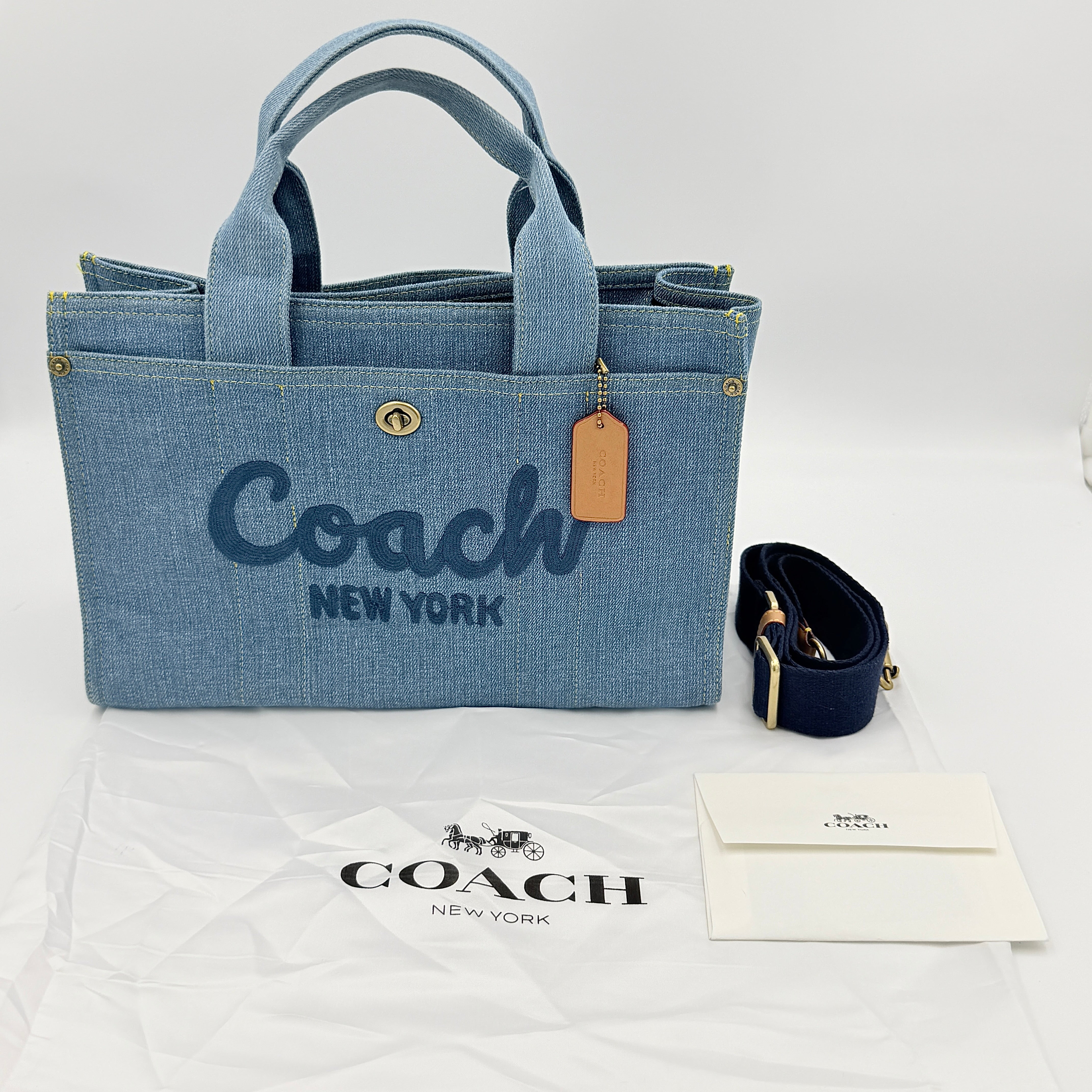 Coach denim 2Way Logo 20 Tote Bag in blue, embroidered with 'Coach New York', shown with detachable navy strap.