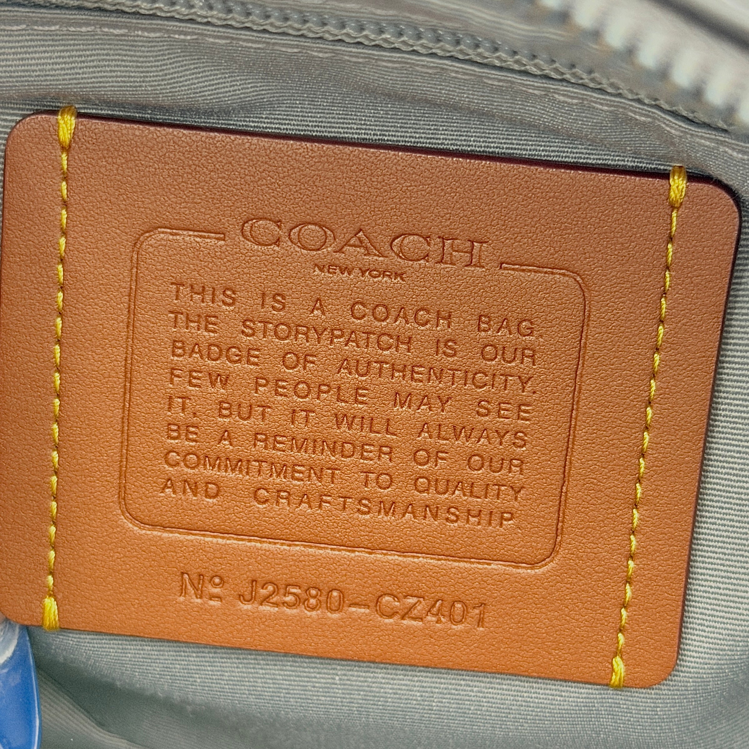 Coach Signature Elias Crossbody Bag in white canvas with black leather trim and silver hardware, styled with an adjustable black strap.