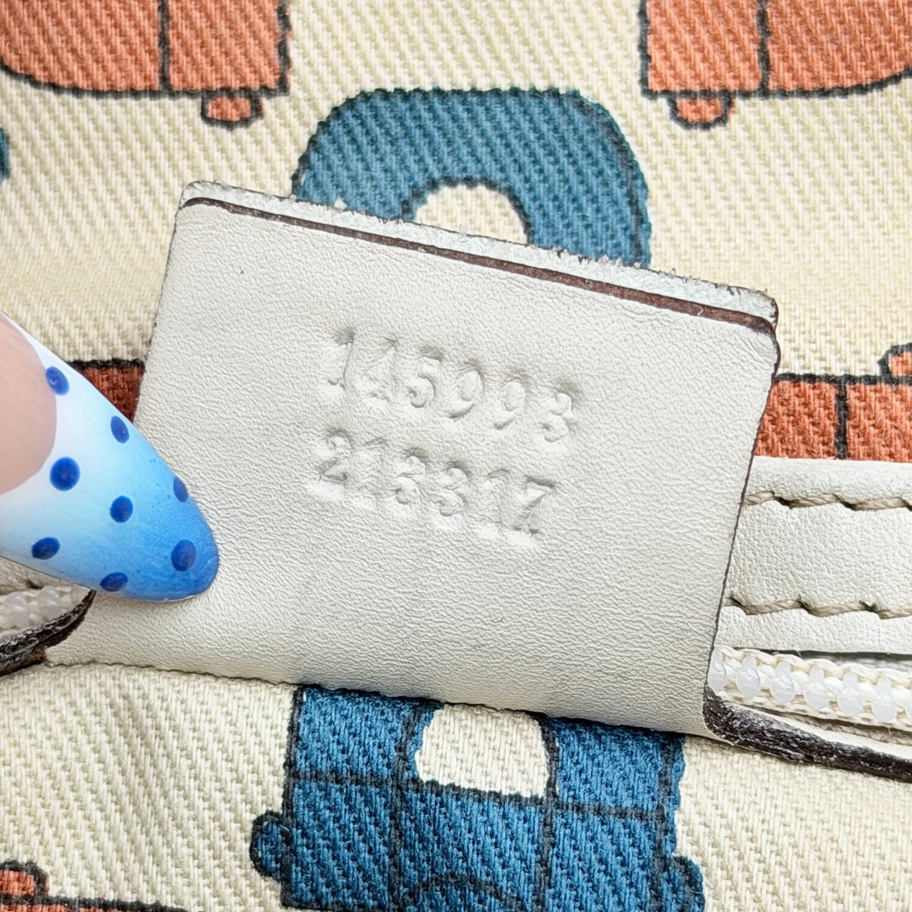 Cream Gucci GG Monogram Guccissima Punch Shoulder Bag with gold hardware, sculpted corners, and double top handles against a white background.