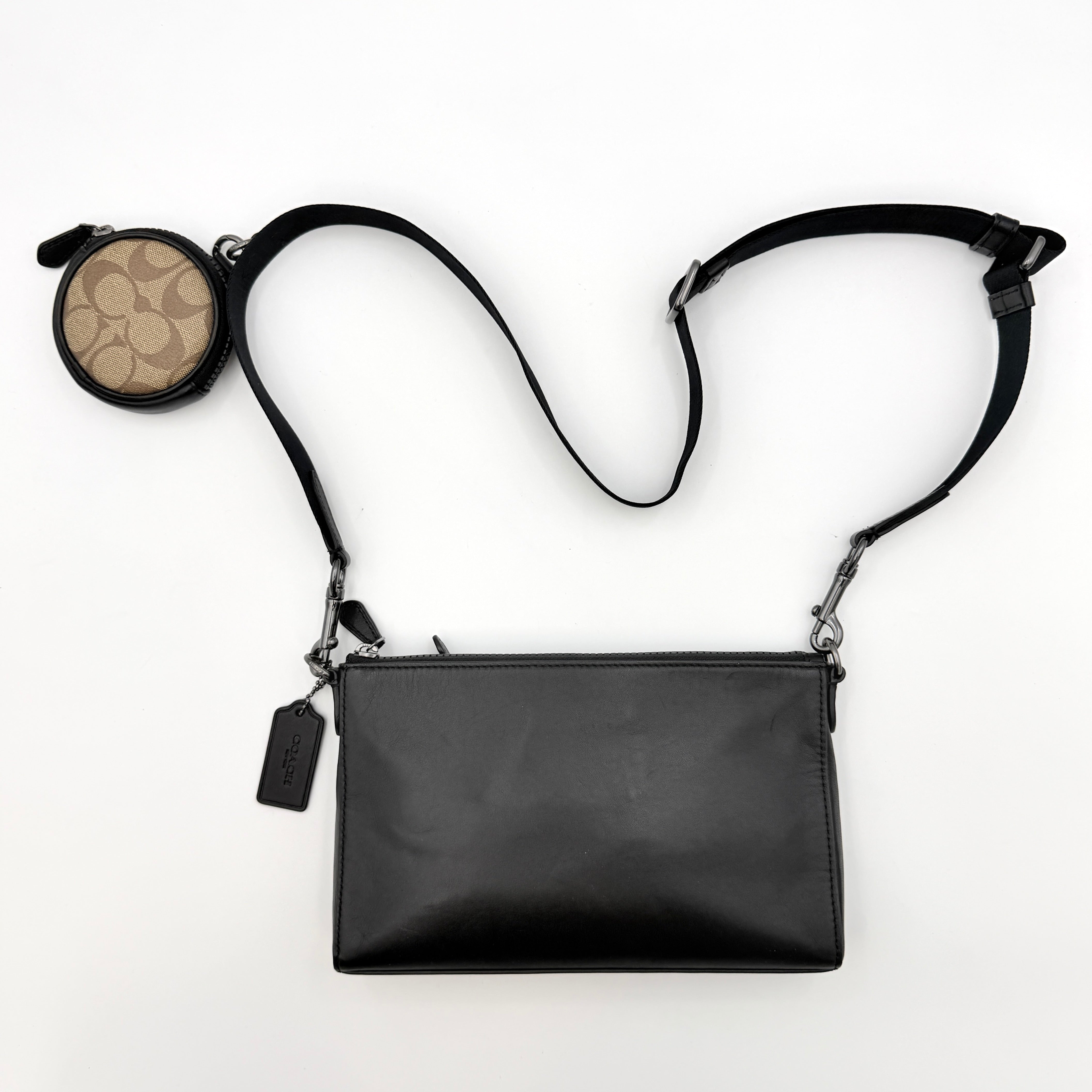 Coach Signature Holden Crossbody Bag in black with beige round coin pouch, featuring coated canvas and leather panels against a white background.