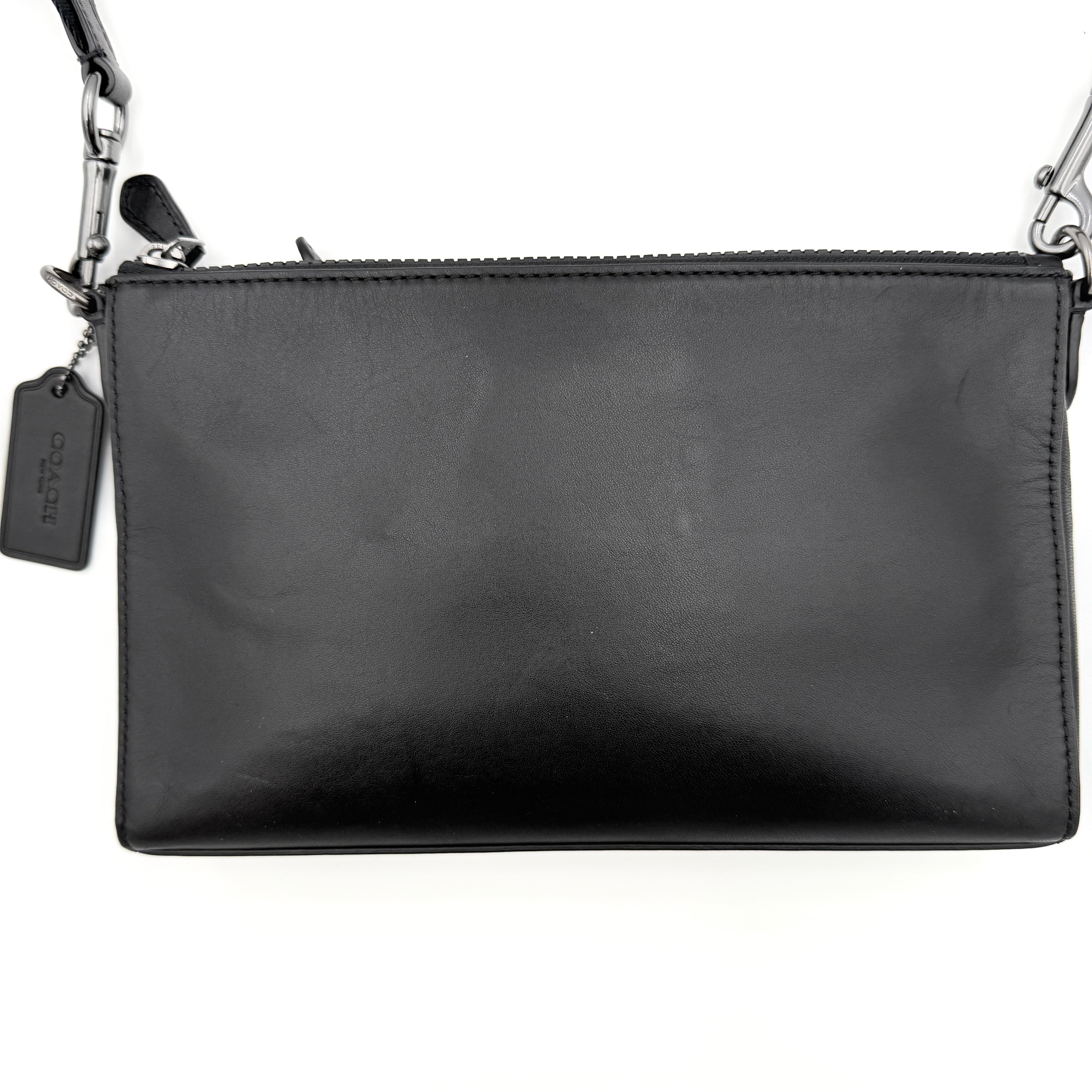 Coach Signature Holden Crossbody Bag in black with beige round coin pouch, featuring coated canvas and leather panels against a white background.