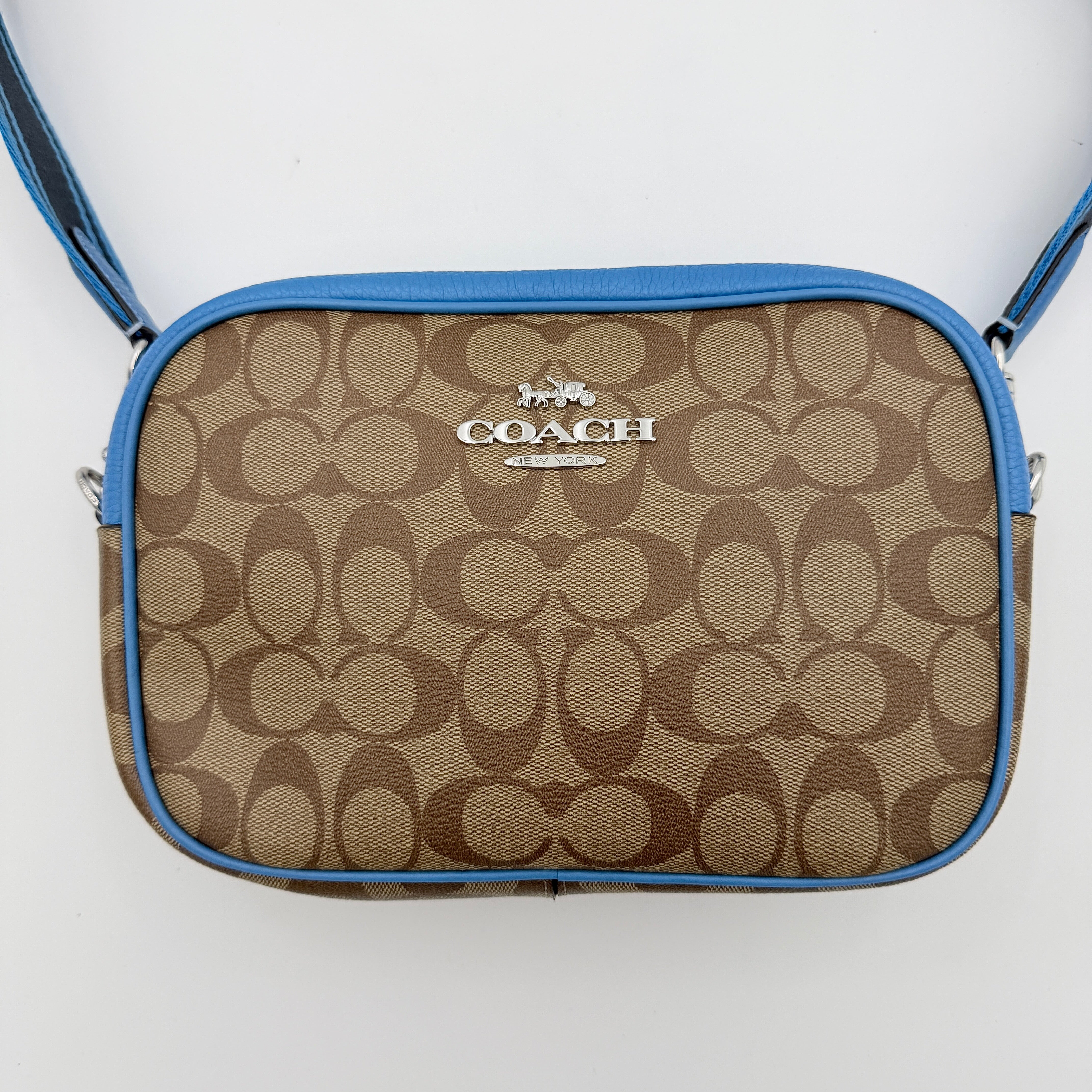 Coach Signature Jamie Crossbody Bag in beige and blue with bold logo webbing strap and blue leather trim, photographed against a white background.