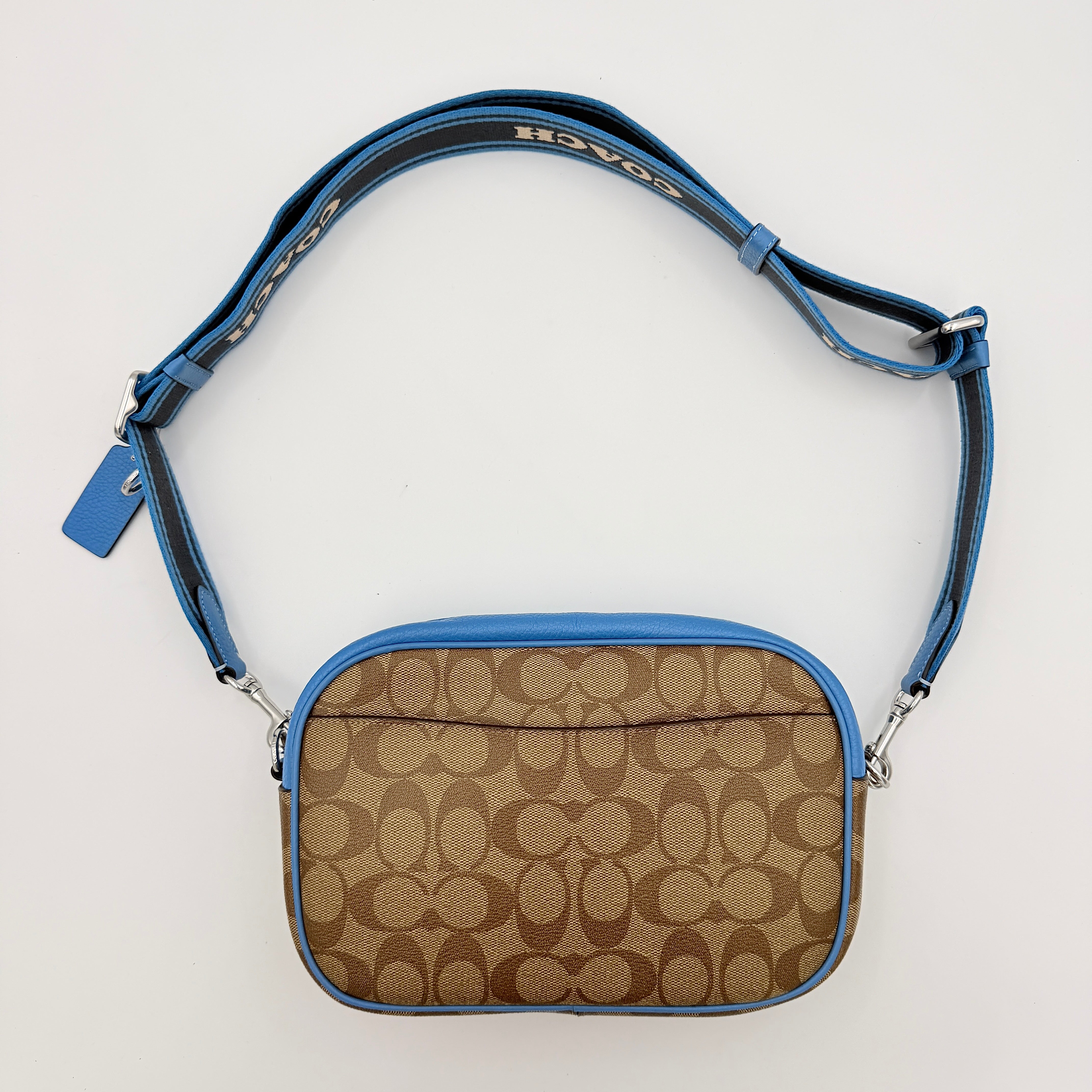 Coach Signature Jamie Crossbody Bag in beige and blue with bold logo webbing strap and blue leather trim, photographed against a white background.