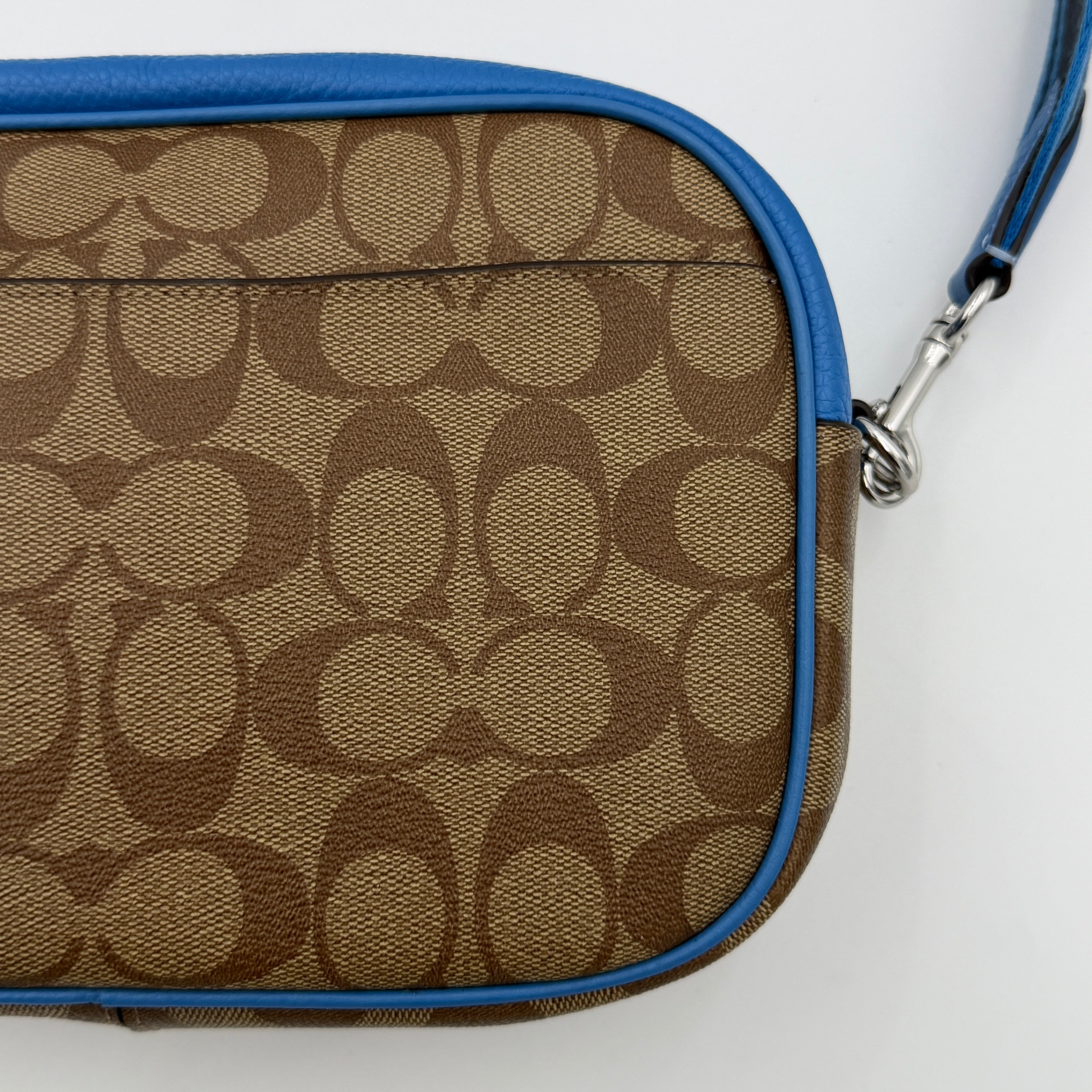 Coach Signature Jamie Crossbody Bag in beige and blue with bold logo webbing strap and blue leather trim, photographed against a white background.