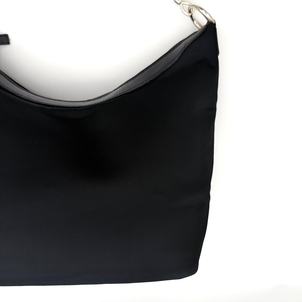 Gucci black nylon shoulder bag with bamboo handle and silver-tone hardware against a white background.