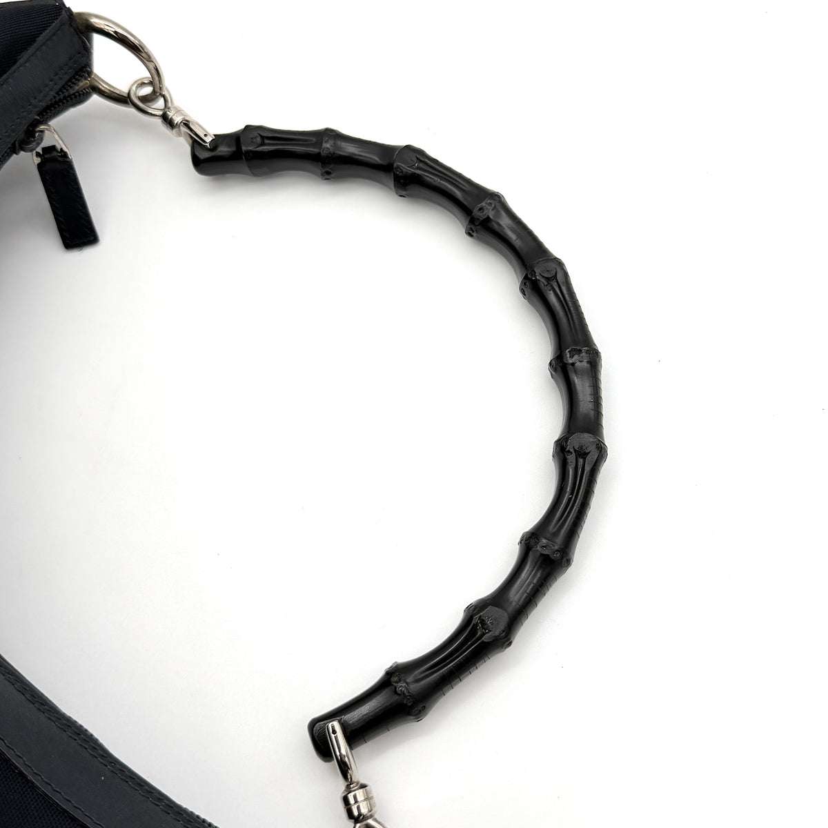 Gucci black nylon shoulder bag with bamboo handle and silver-tone hardware against a white background.