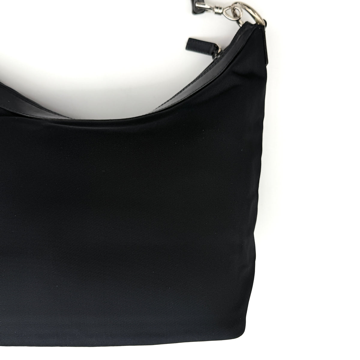 Gucci black nylon shoulder bag with bamboo handle and silver-tone hardware against a white background.