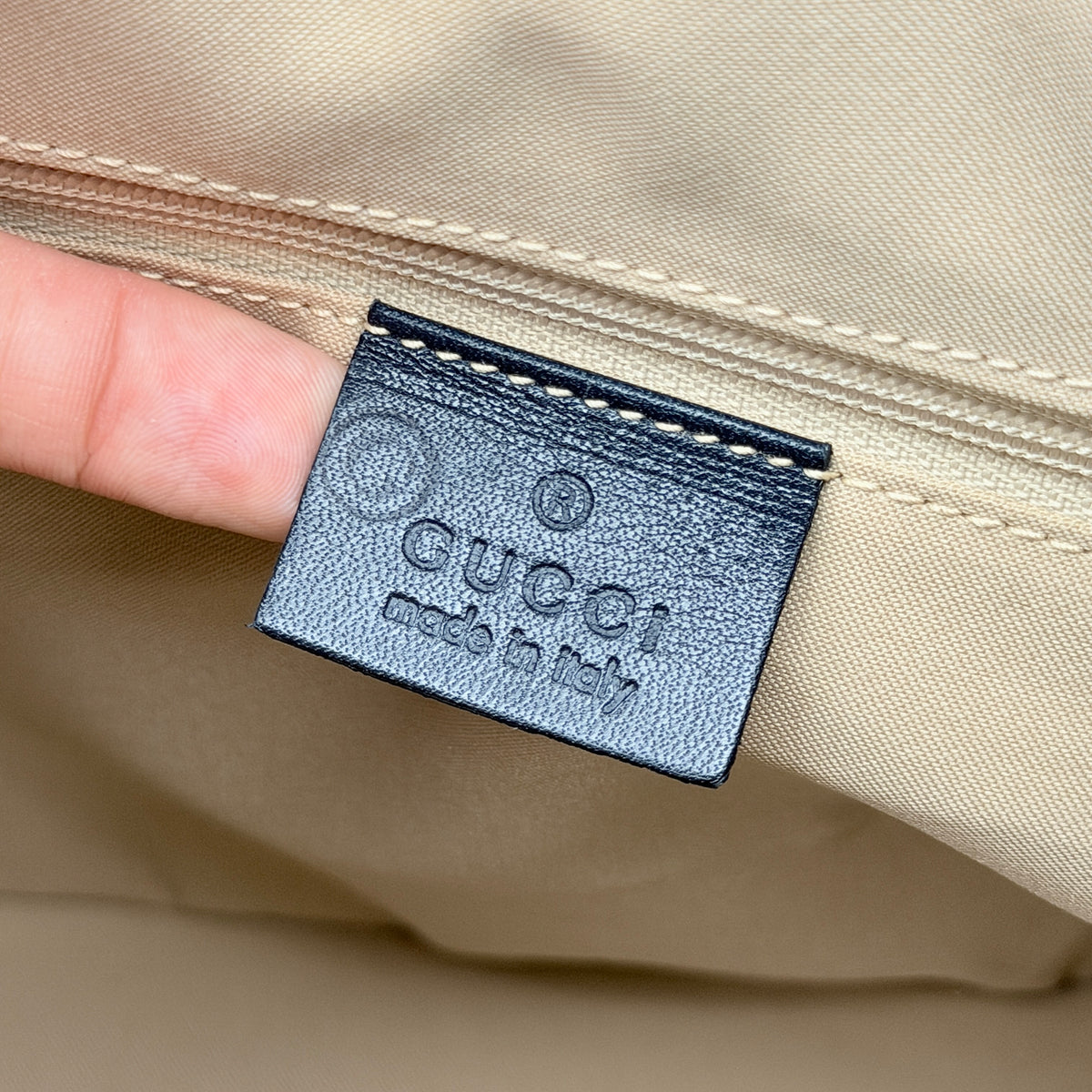 Gucci black nylon shoulder bag with bamboo handle and silver-tone hardware against a white background.