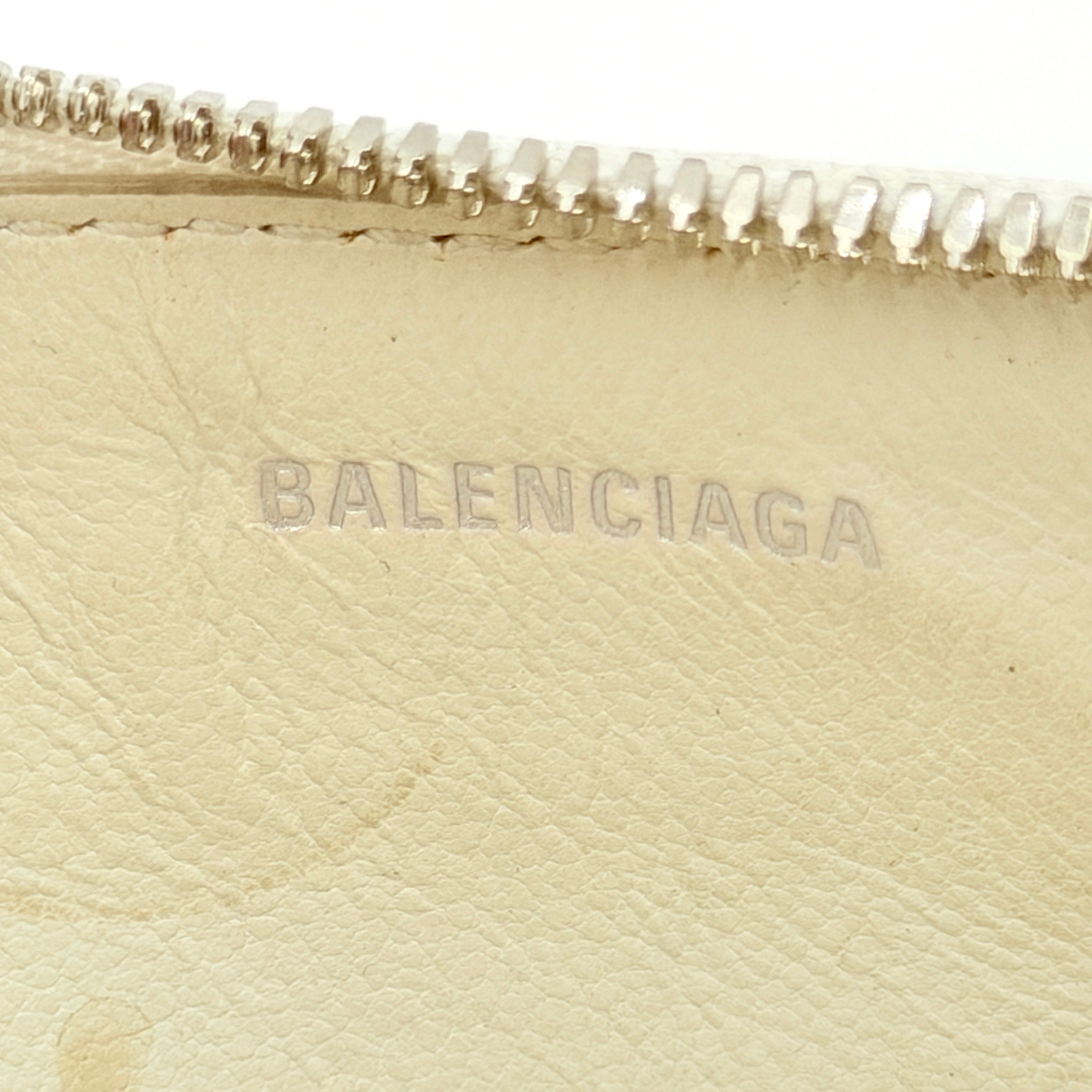 Balenciaga white leather card holder with playful red hearts and zip closure, set against a clean background.