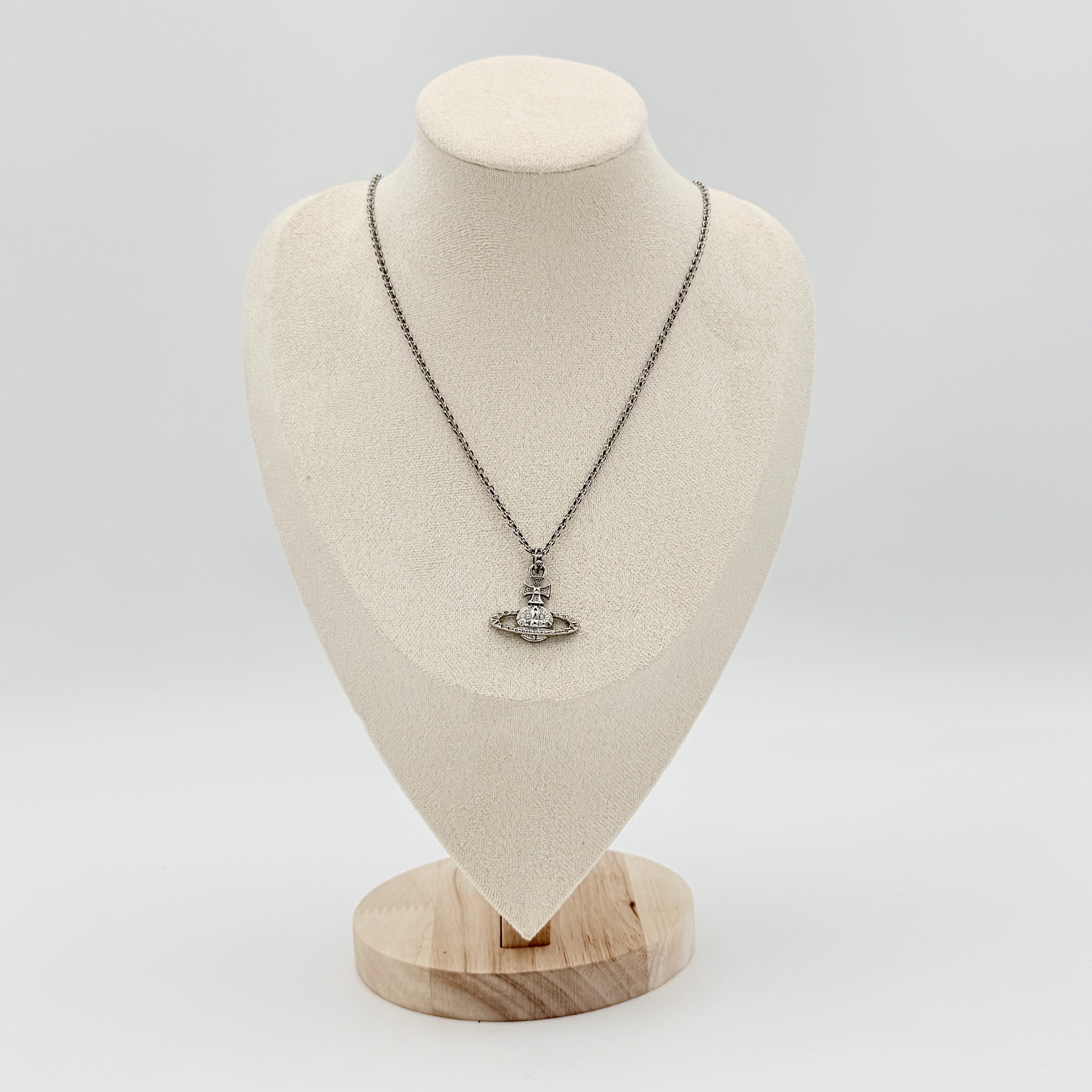 Vivienne Westwood silver orb necklace with crystal-studded Saturn motif on a textured chain, displayed against a clean background.
