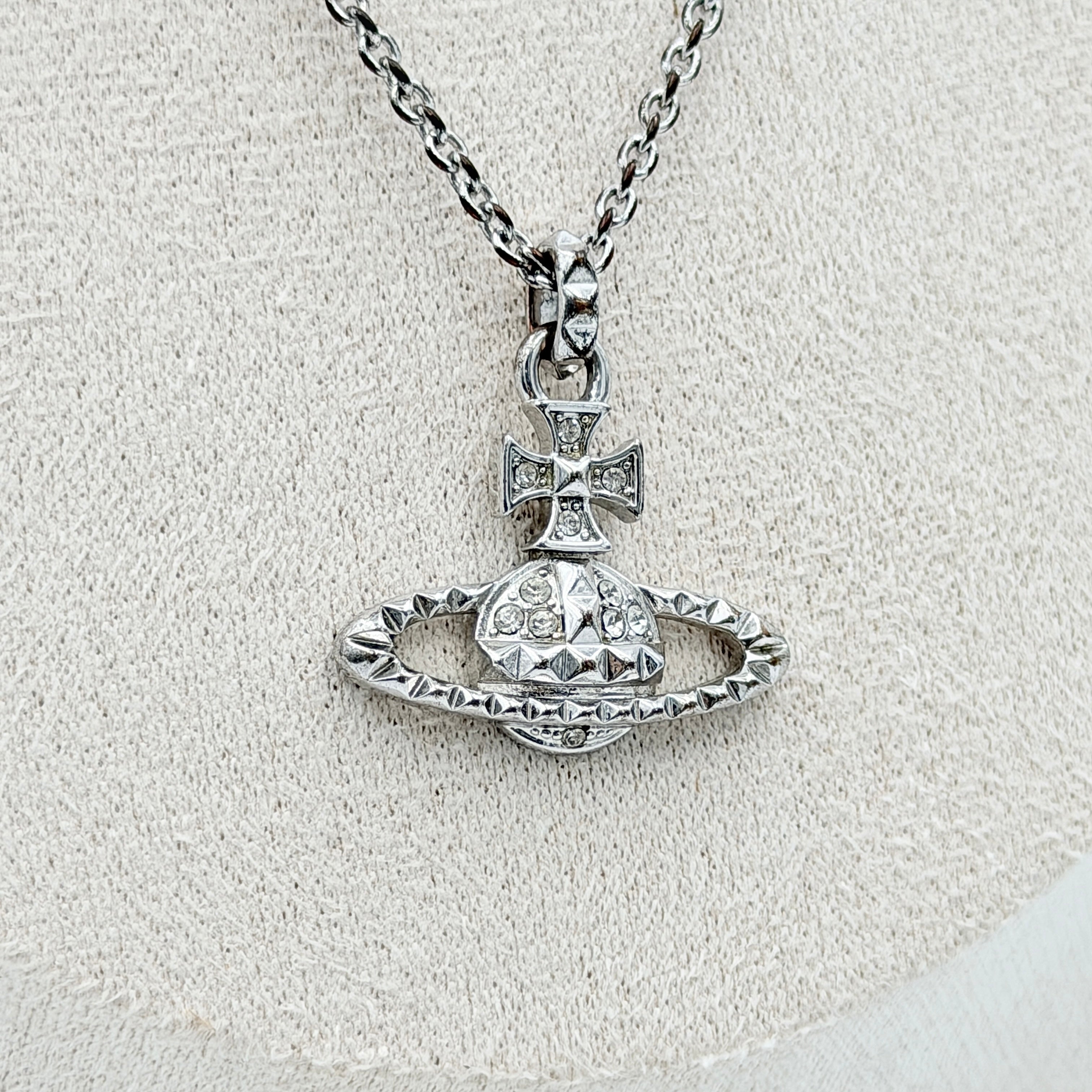 Vivienne Westwood silver orb necklace with crystal-studded Saturn motif on a textured chain, displayed against a clean background.