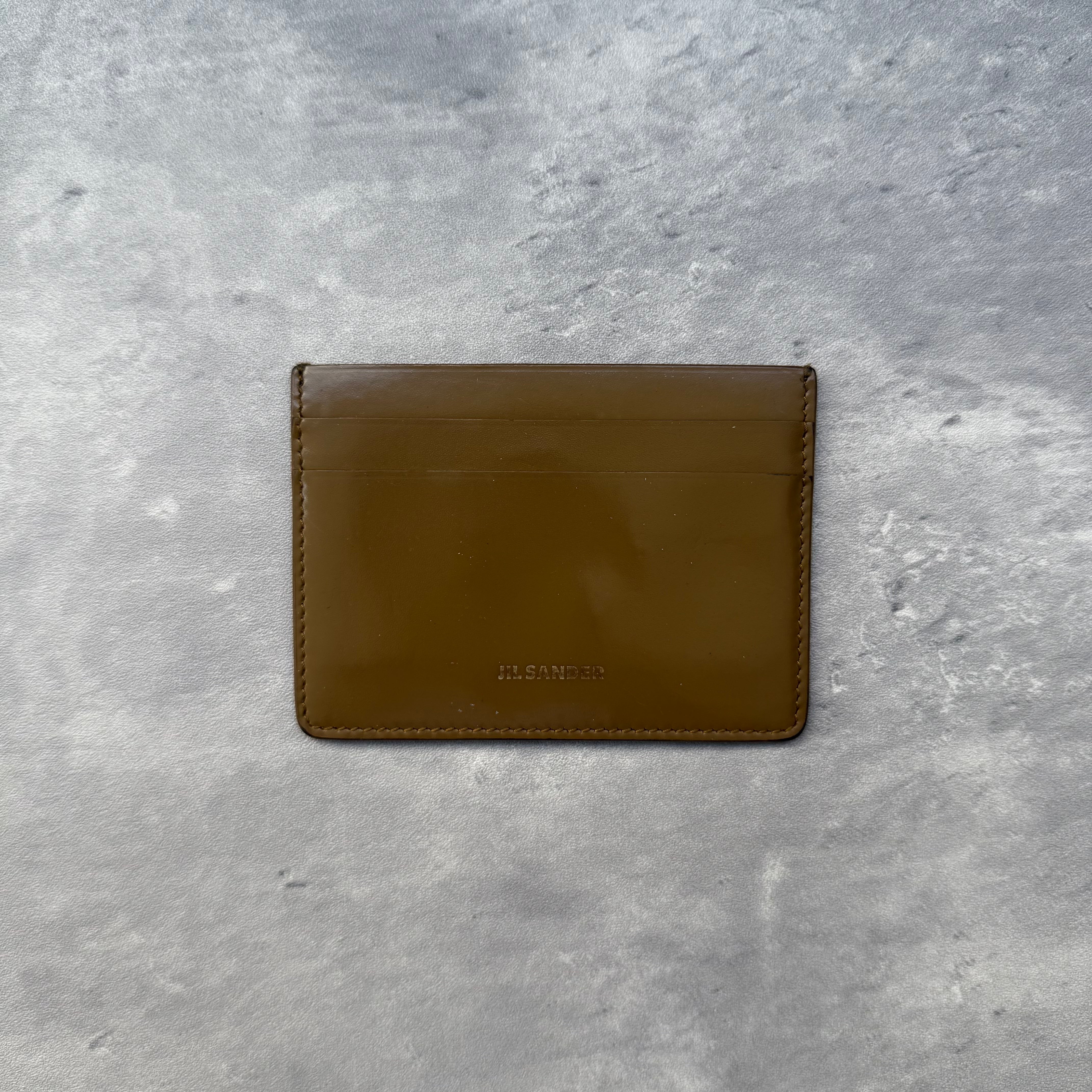 Jil Sander Brown Leather Cardholder with multiple slots and central slip pocket, slim minimalist design.