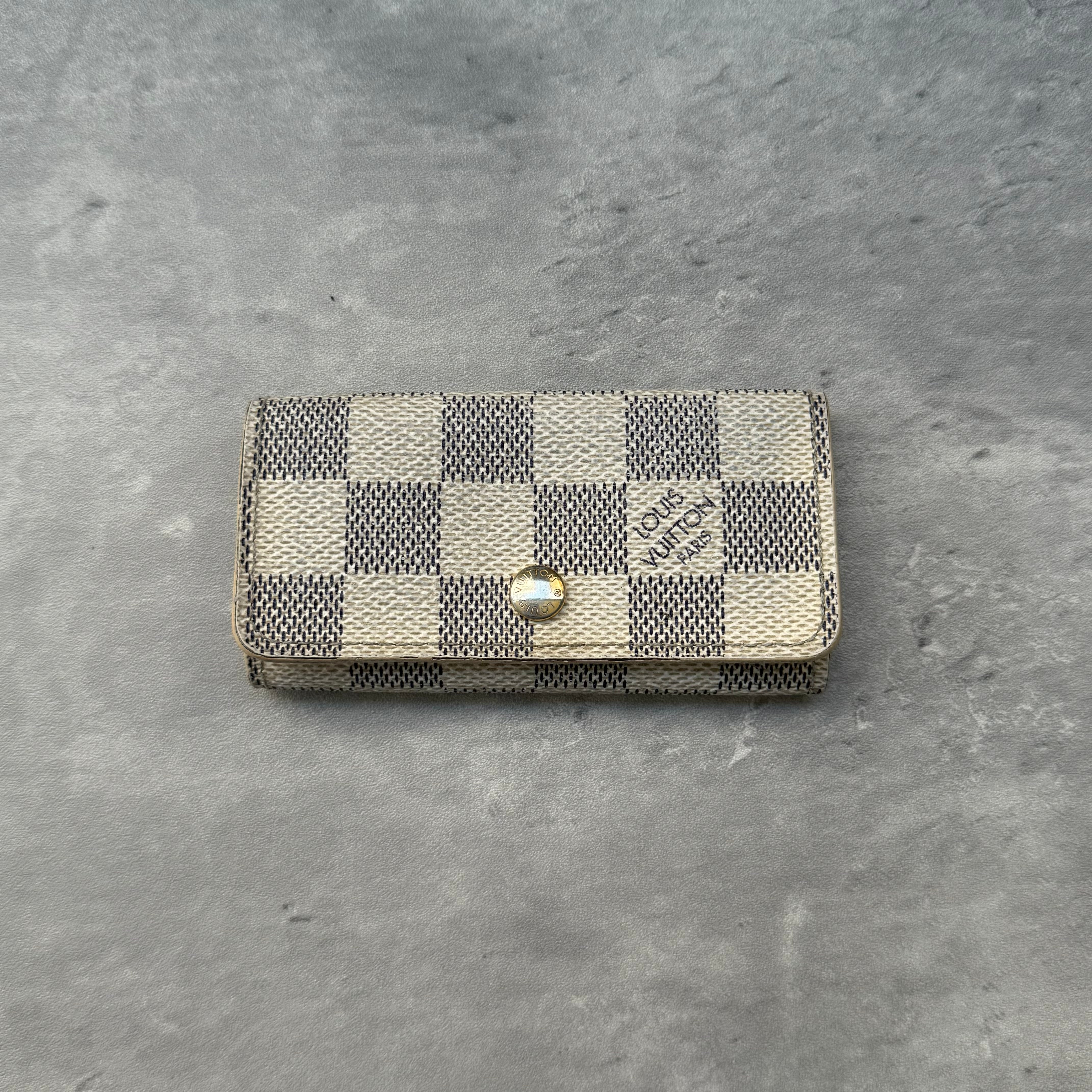 Louis Vuitton Damier Azur Key Holder, crafted from coated canvas with gold-tone hardware and four interior key hooks.