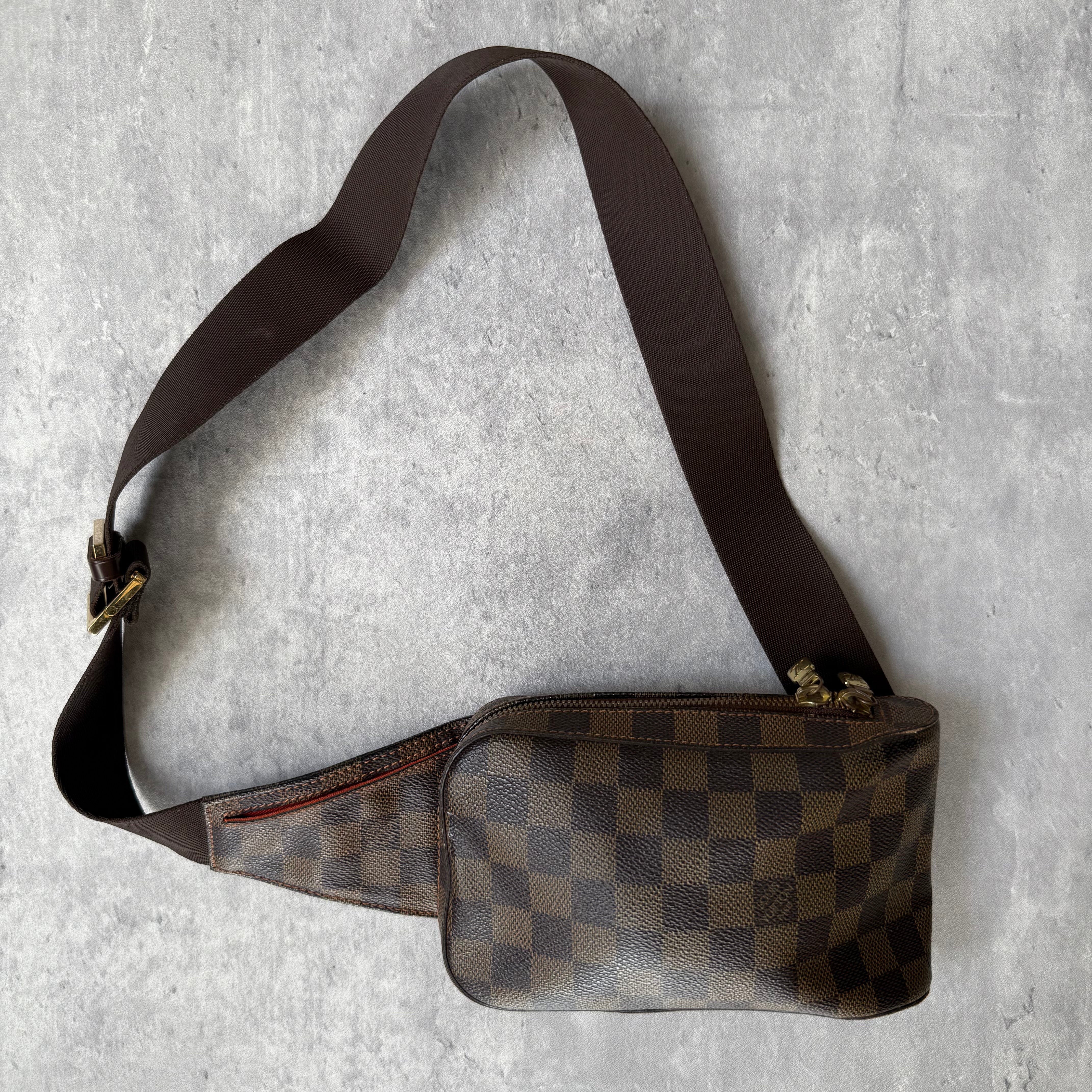 Louis Vuitton Geronimos Bag in brown Damier Ebene canvas with adjustable strap, red interior, and zip closure.