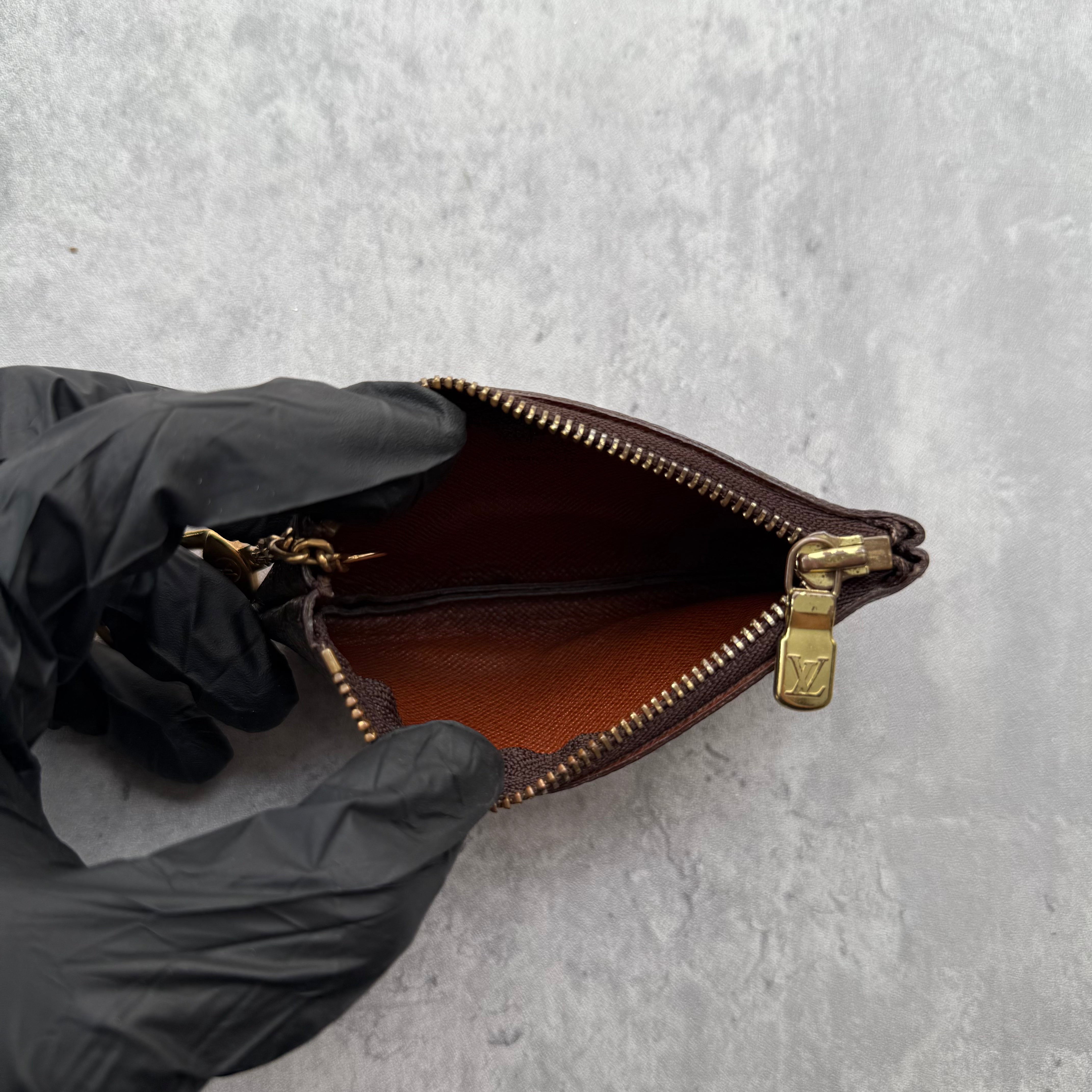 Louis Vuitton Monogram Coin Purse in coated canvas with gold-tone chain and zip-top closure.