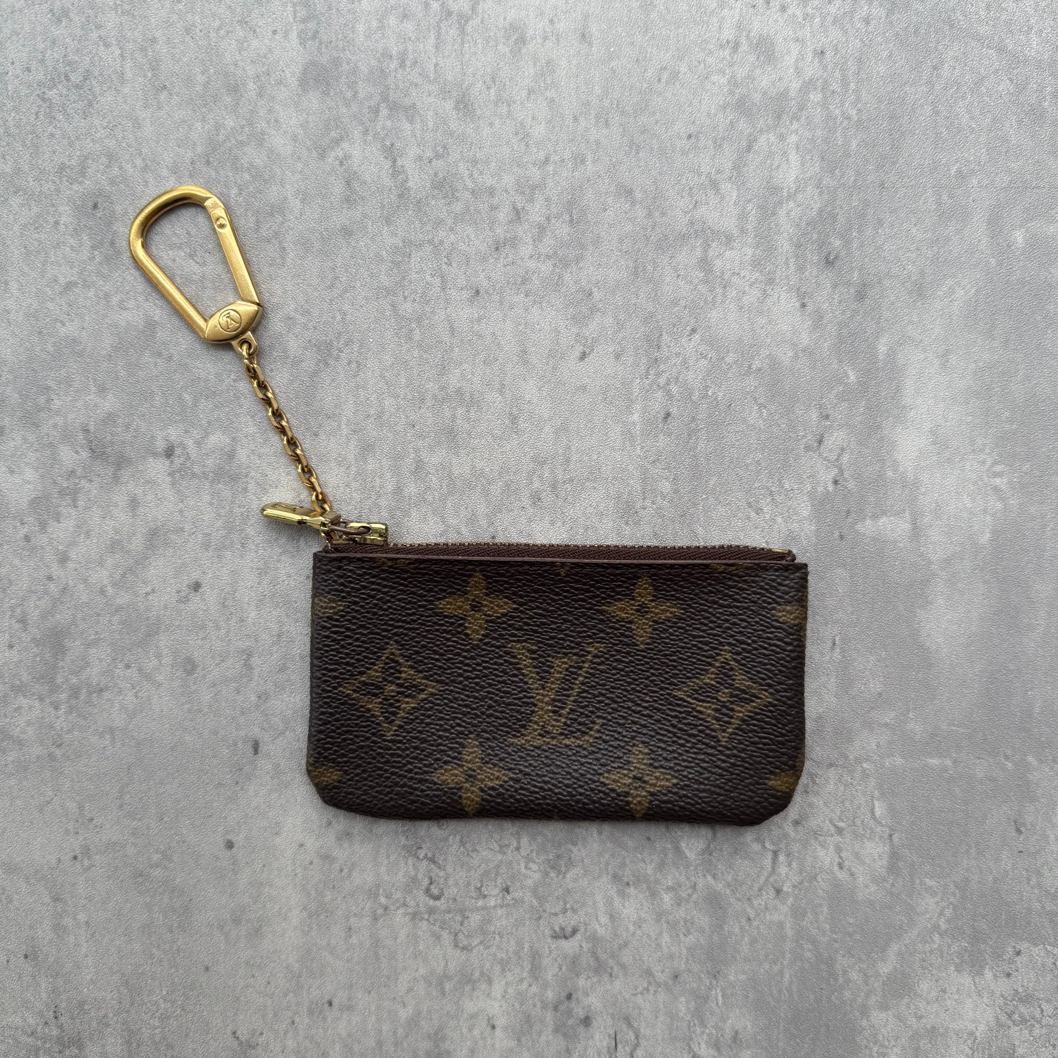 Louis Vuitton Monogram Coin Purse in coated canvas with gold-tone chain and zip-top closure.