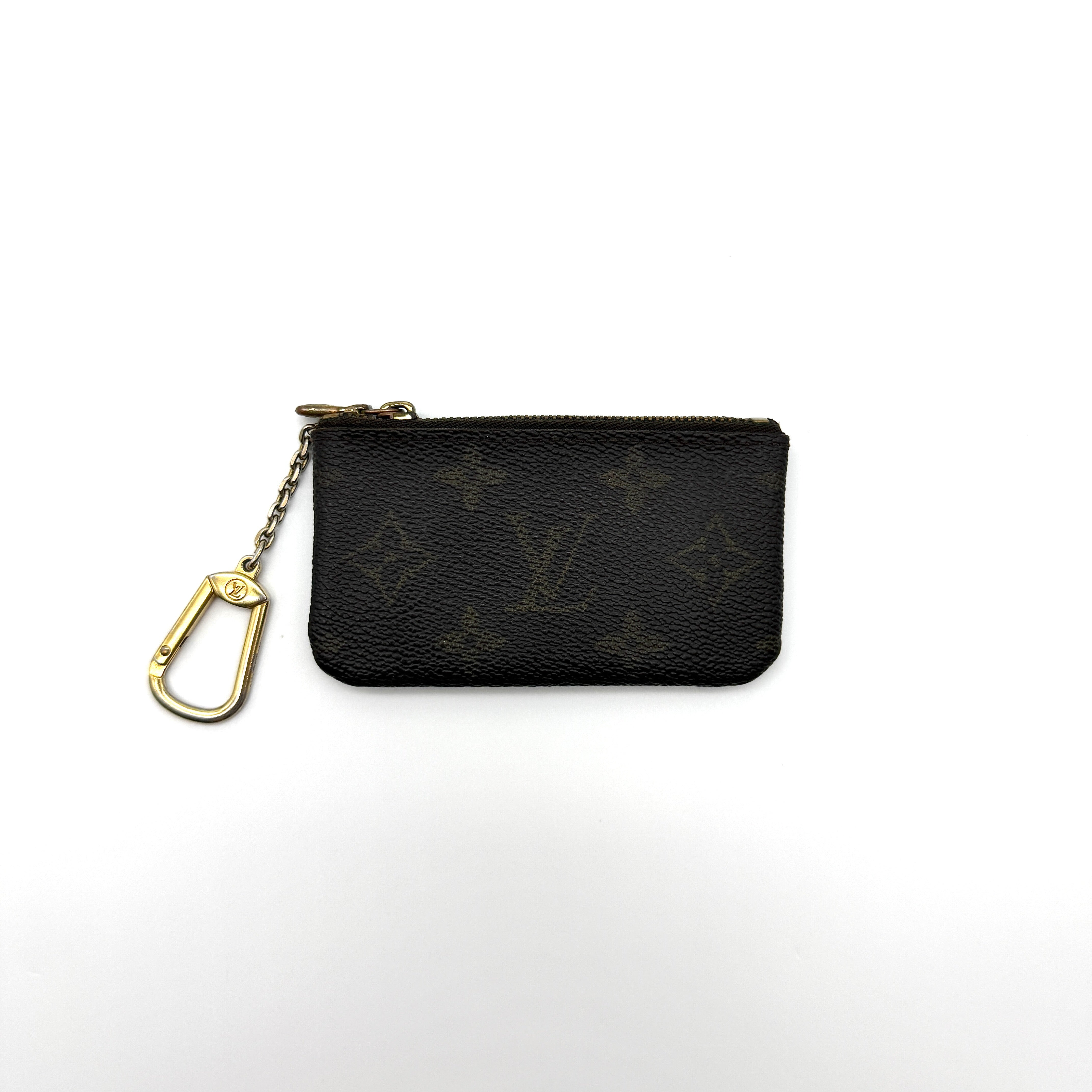 Louis Vuitton Monogram Coin Purse with gold-tone zipper and clasp, crafted in coated canvas with brown leather interior