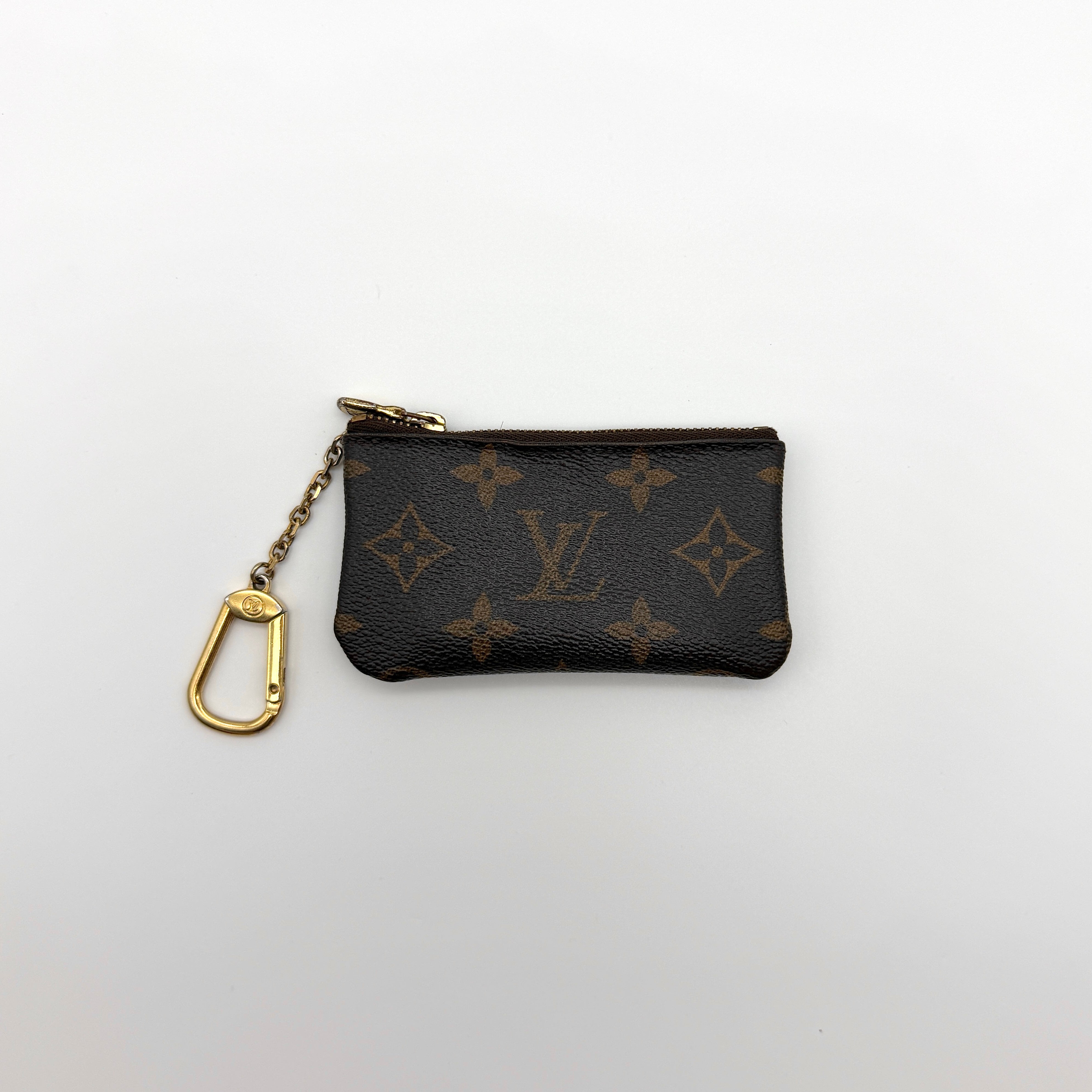 Louis Vuitton Monogram Coin Purse with gold-tone zipper and clasp, crafted in coated canvas with brown leather interior