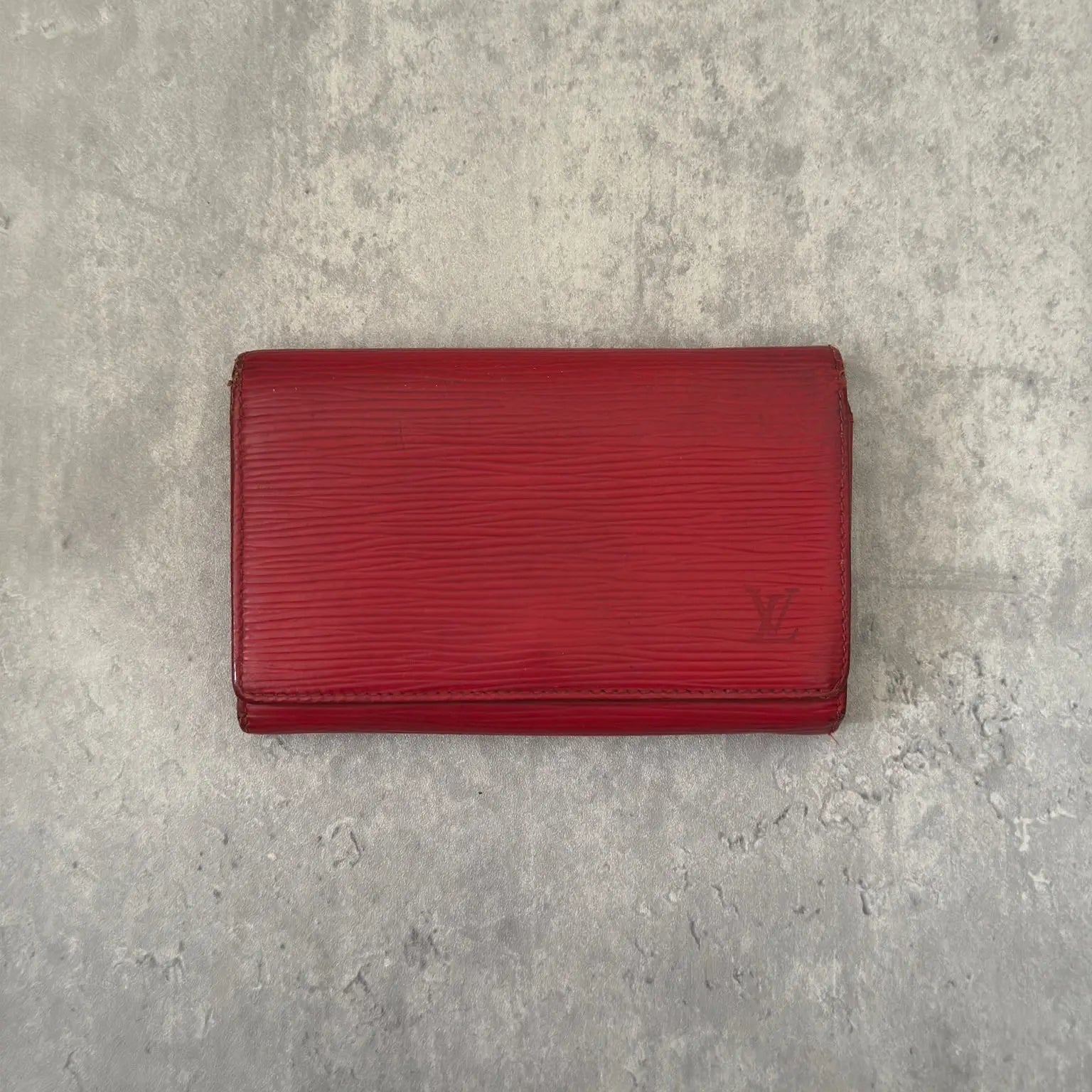 Louis Vuitton International Wallet in red Epi leather, featuring embossed LV logo, textured surface, multiple card slots, and gold-tone hardware. Compact and elegant, perfect for daily use.