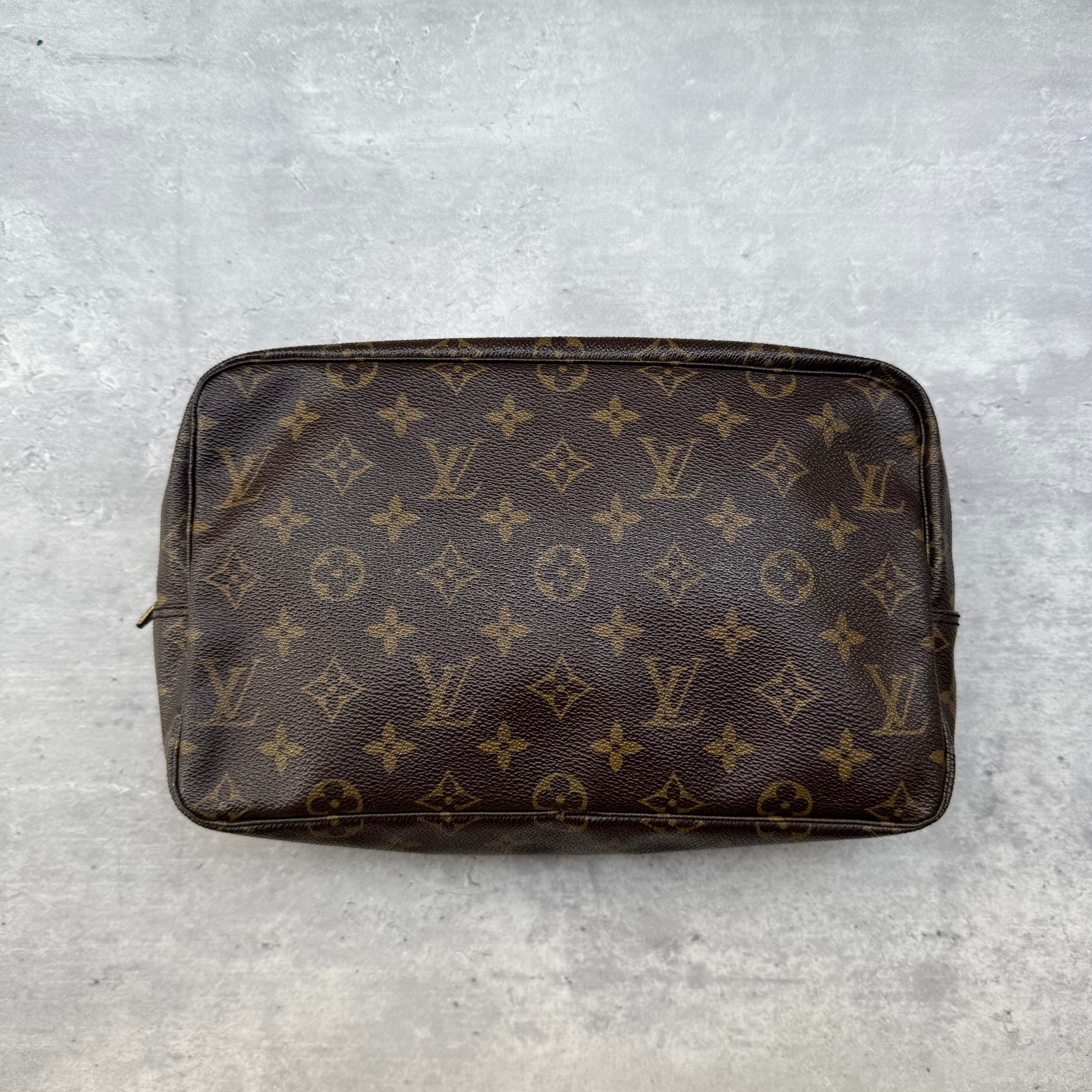 Louis Vuitton Trousse de Toilette Monogram Washbag in brown coated canvas with gold-tone zipper and beige leather lining