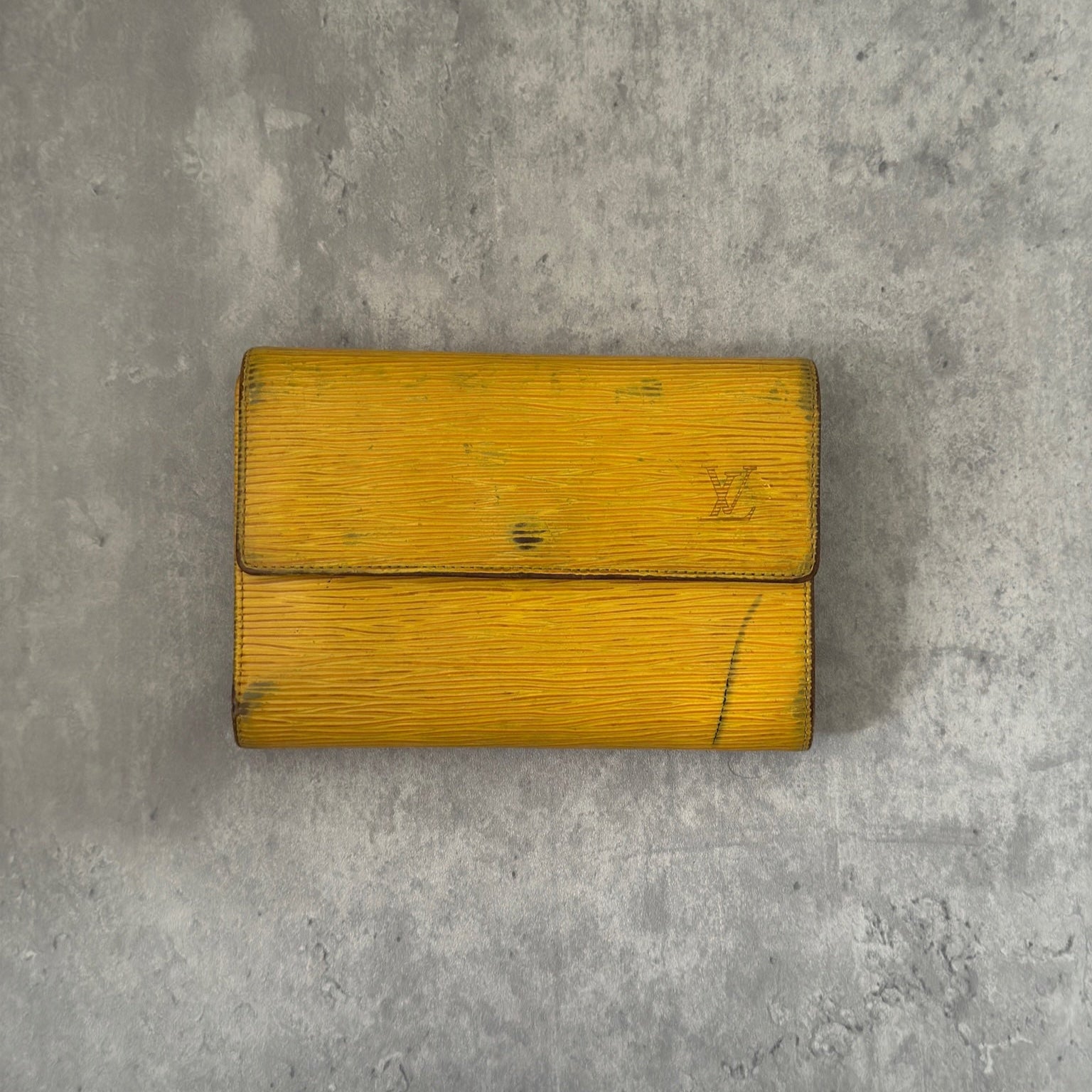 Louis Vuitton Epi leather wallet in yellow with purple leather interior, showcasing multiple card slots and a spacious bill compartment, a blend of functionality and luxury.