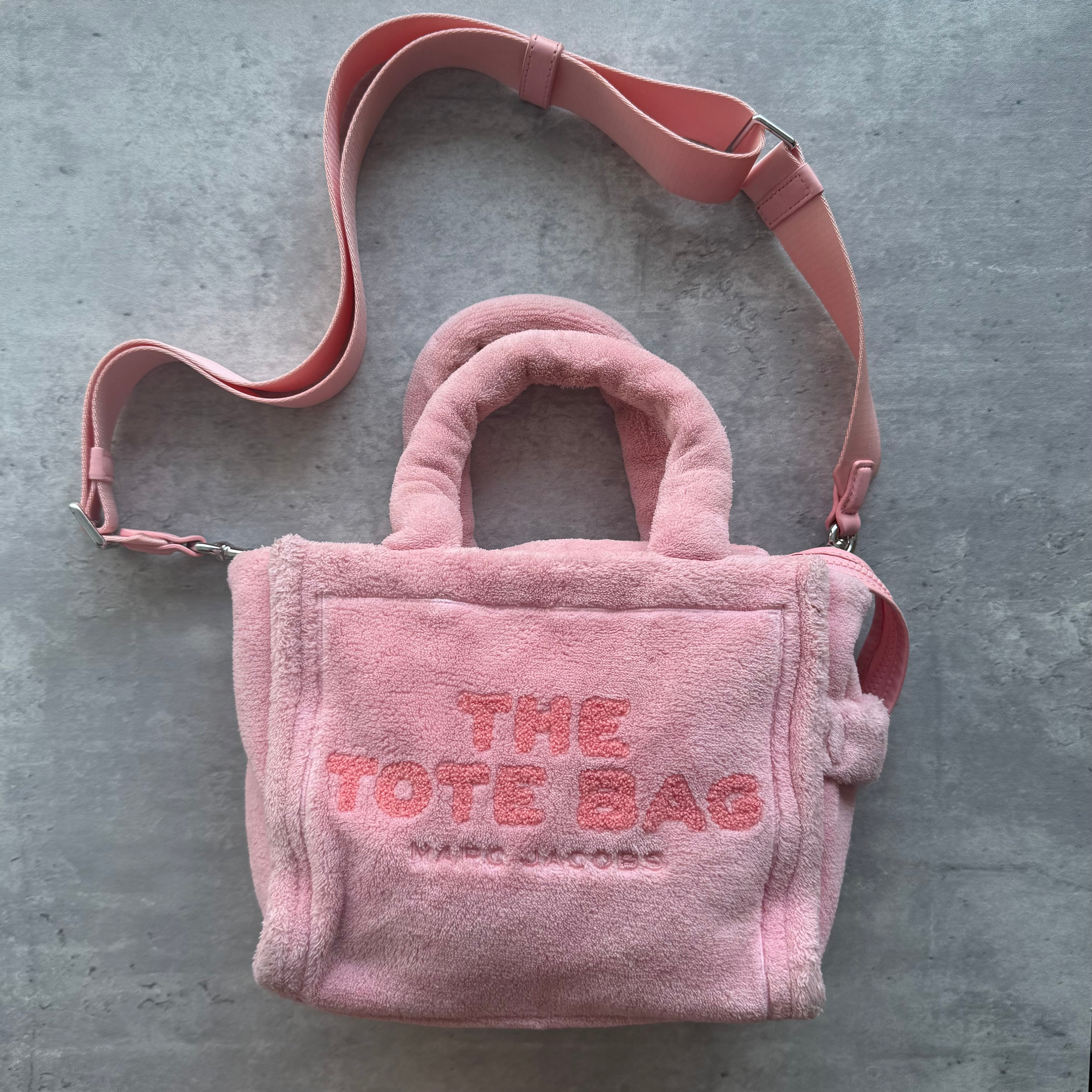 Marc Jacobs Mini Terry Tote Bag in soft pink terry cloth with embroidered logo, leather patch, top handles, and crossbody strap.