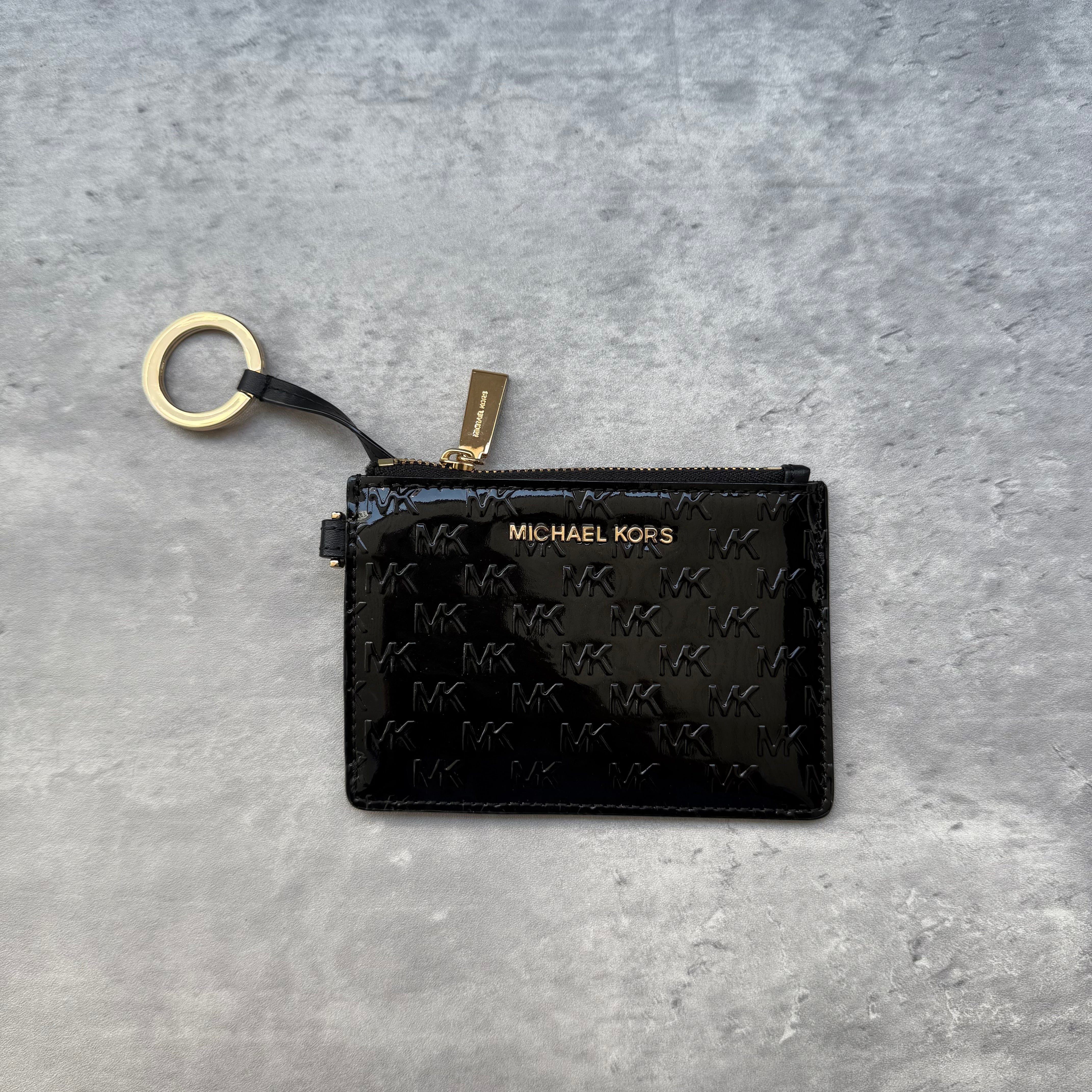 Michael Kors Monogram Key Cardholder Black patent leather with embossed MK logo, gold-tone hardware, and detachable key ring.